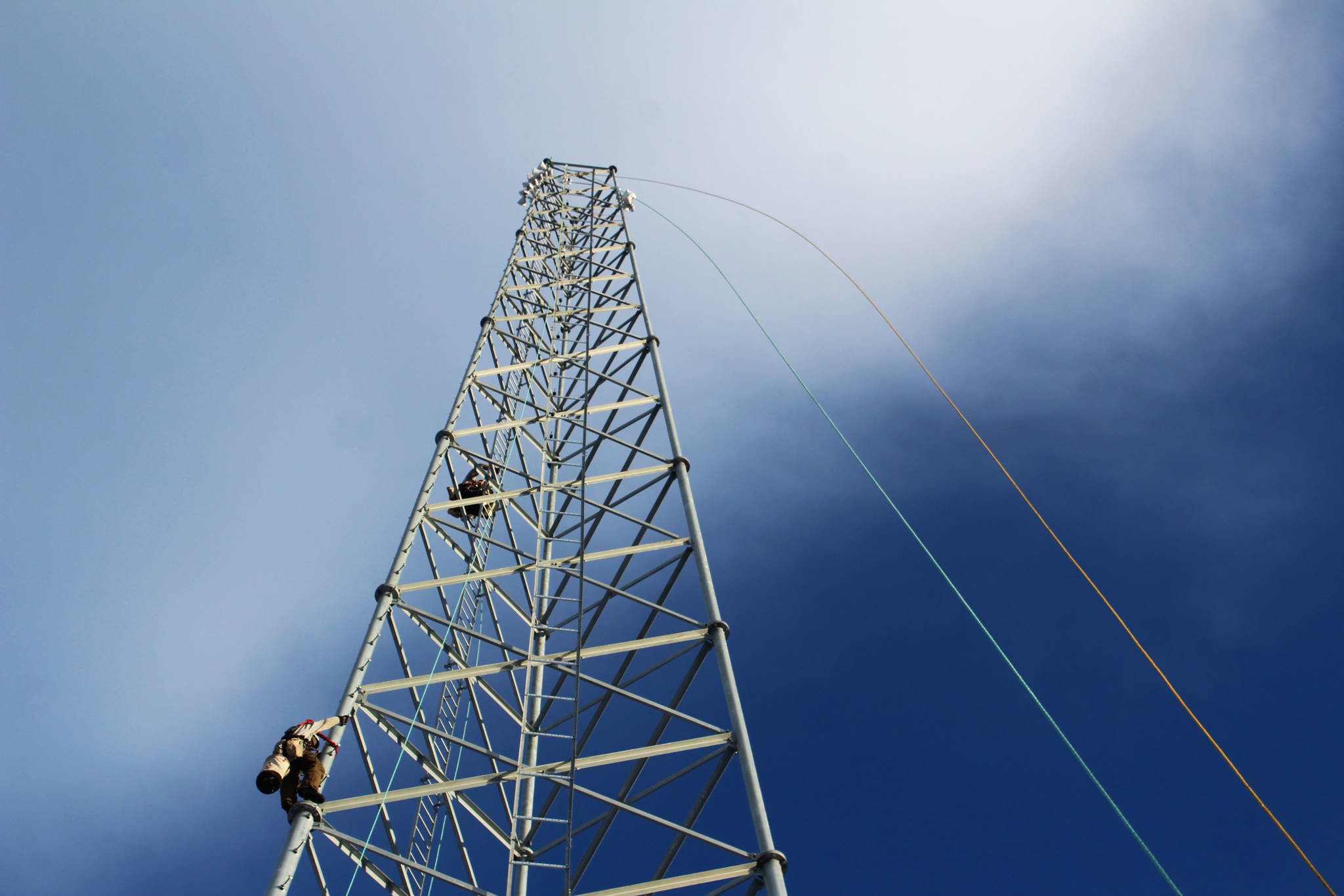 Billy Adamson (left) and Adam Kiffmeyer scale a communications tower on Thursday, Jan. 7 in Nikiski, Alaska. Homer-based SPITwSPOTS was one of the telecommunications companies awarded CARES money by the Kenai Peninsula Borough as part of an effort to increase public access to the internet. (Ashlyn O’Hara/Peninsula Clarion)