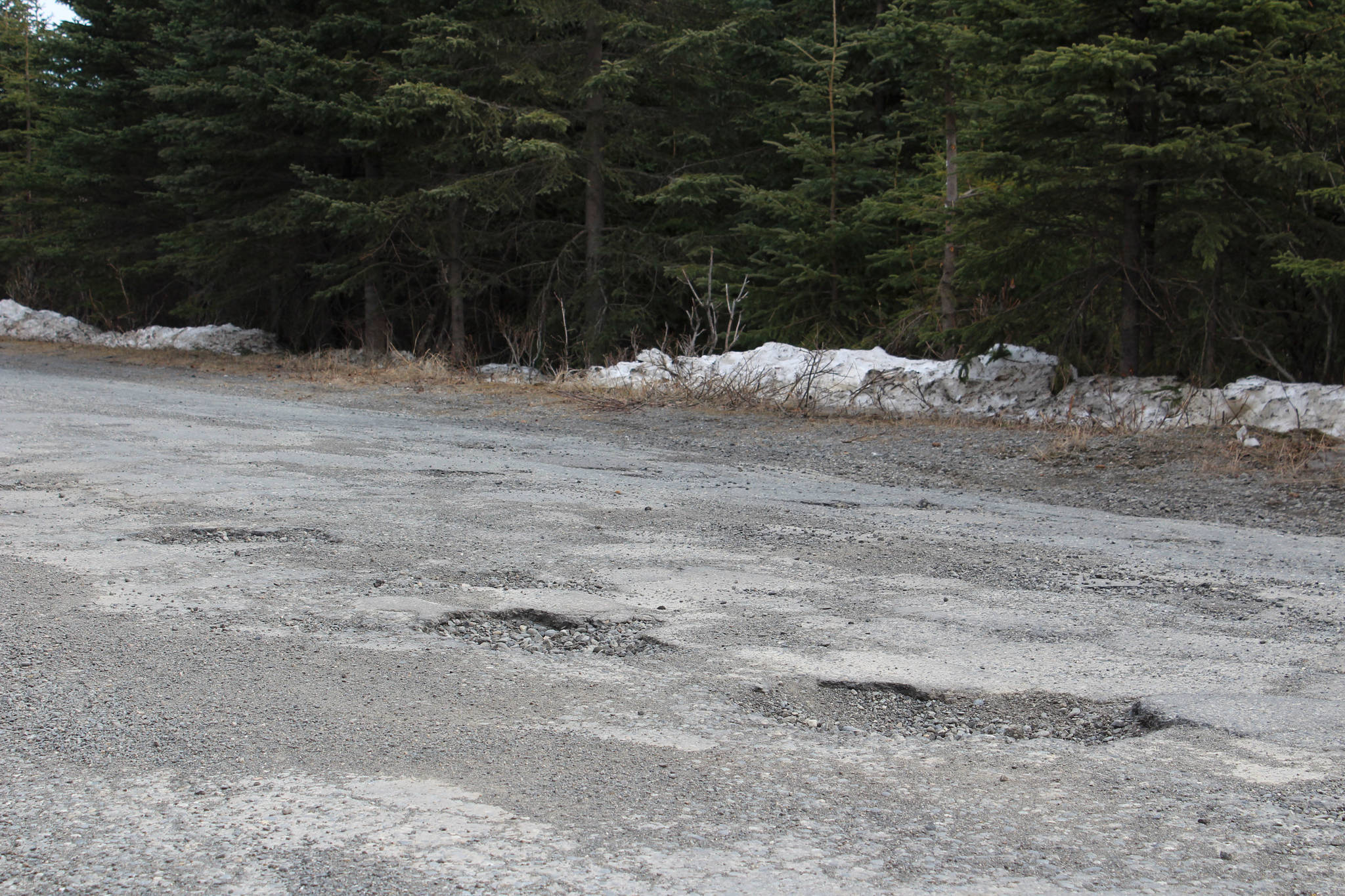 Potholes can be seen on Wildwood Drive on Thursday, April 22 in Kenai, Alaska. (Ashlyn O’Hara/Peninsula Clarion)