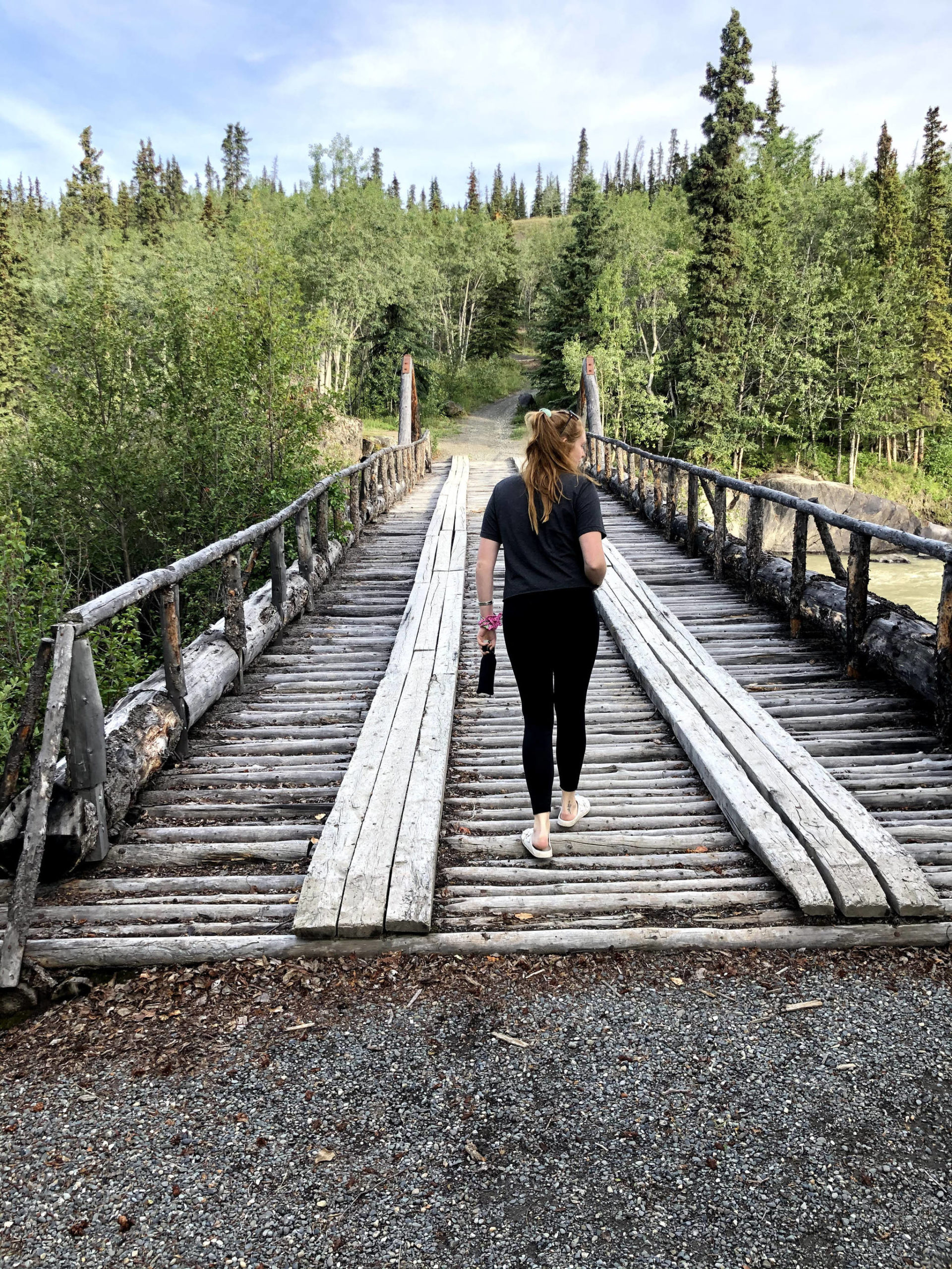 Camille Botello crosses a bridge with her bear spray in a rest stop area off the Alaska Highway on July 17, 2020. (Photo provided)