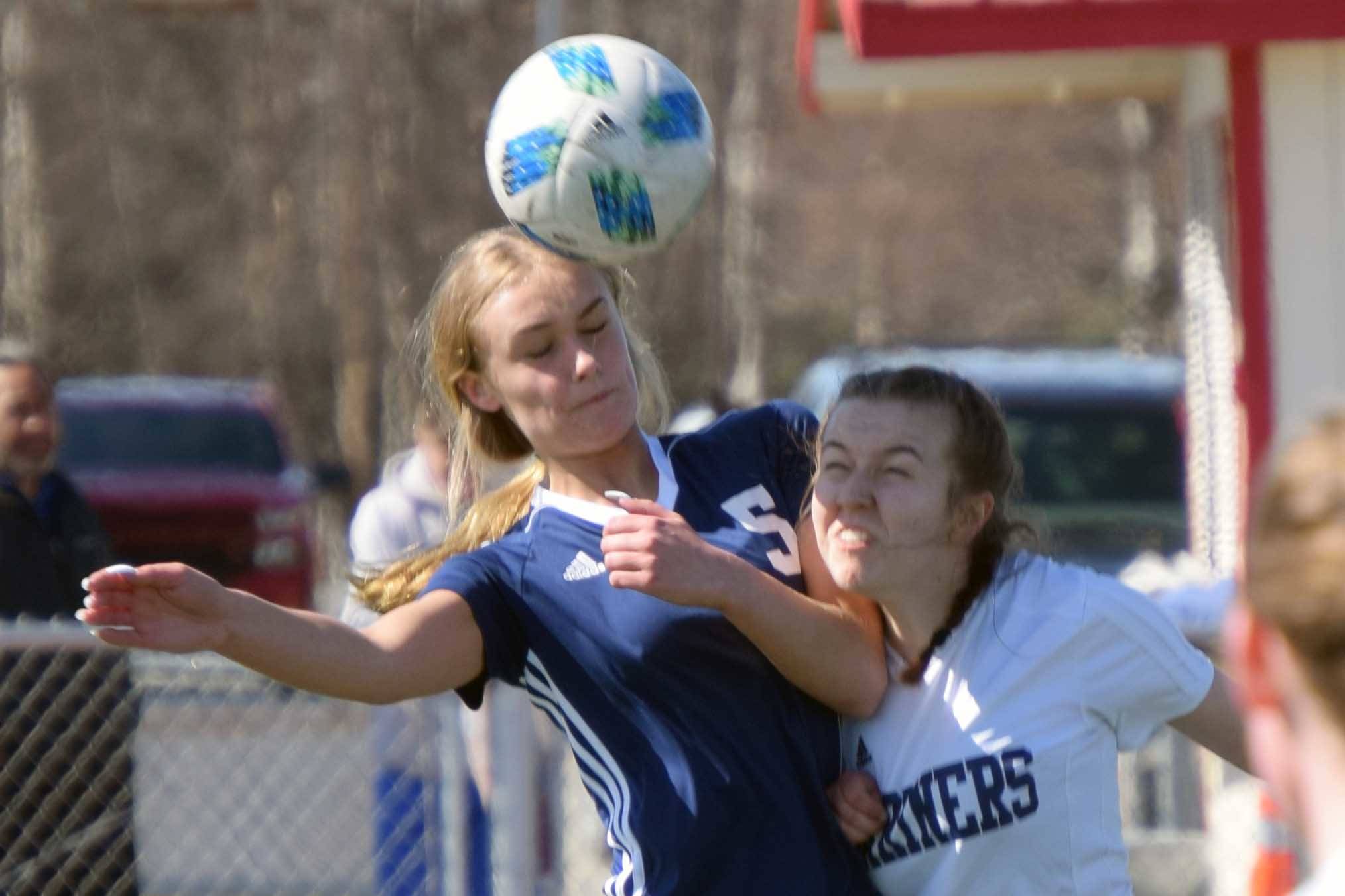 Soldotna's Jolie Widaman and Homer's Kappa Reutov challenge for the ball Saturday, April 24, 2021, at Kenai Central High School in Kenai, Alaska. (Photo by Jeff Helminiak/Peninsula Clarion)