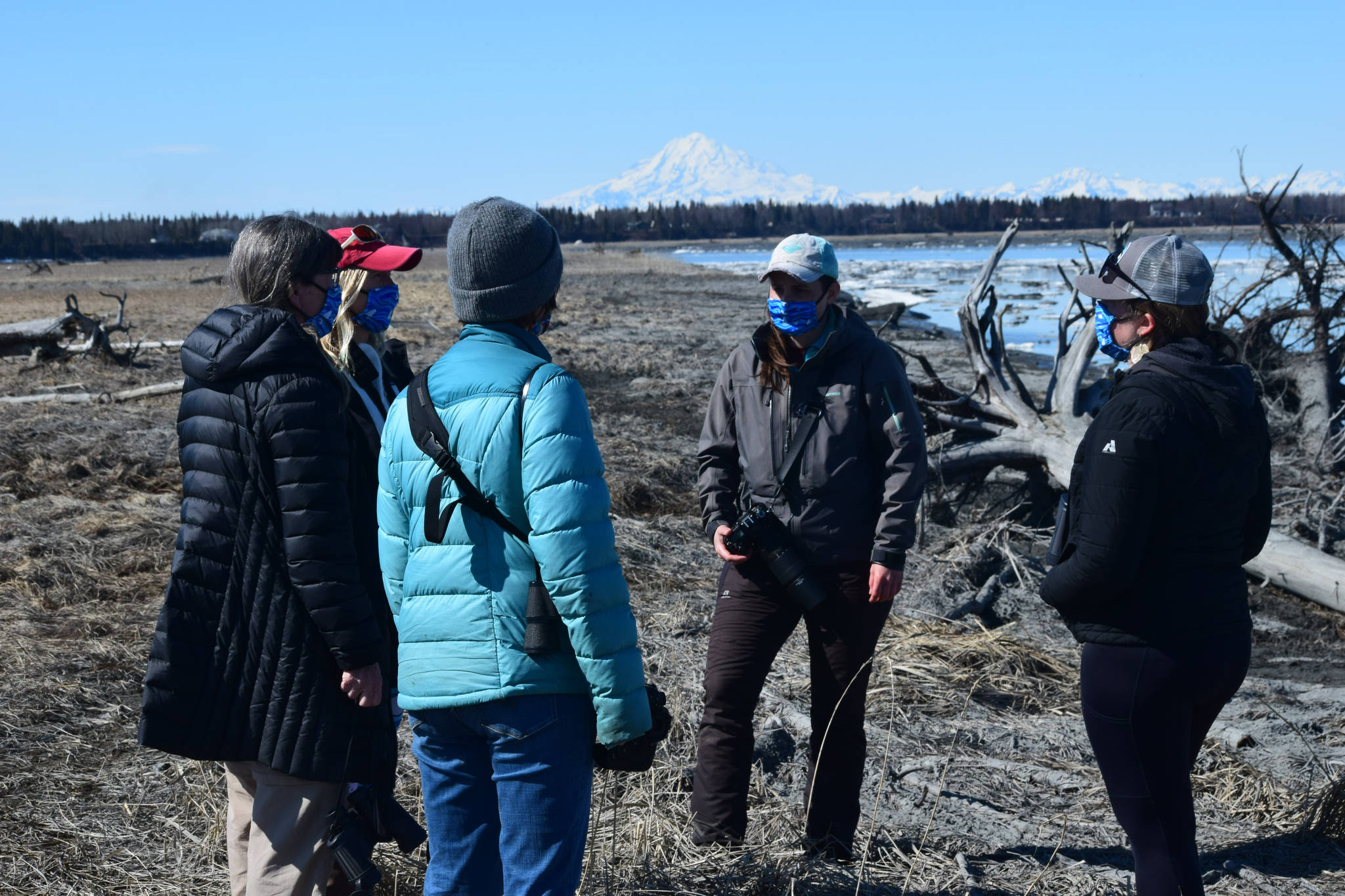 From left to right, counter-clock wise: Mia Werger, Teresa Becher, Deborah Boege Tobin, Madison Kosma, and Suzanne Steinert monitor beluga whales at the Kenai River on Saturday, April 24, 2021. (Photo by Camille Botello/Peninsula Clarion)