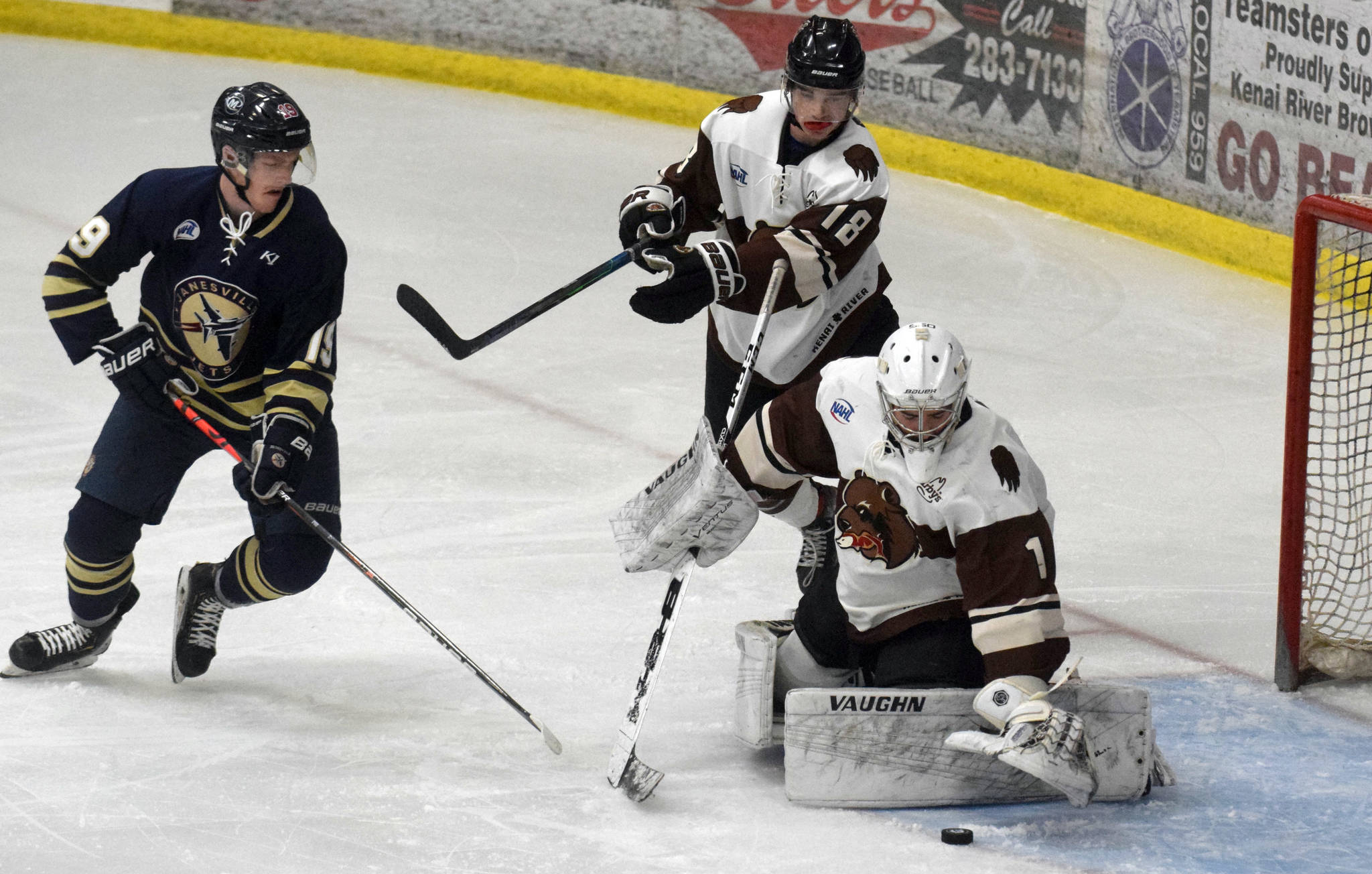 Kenai River Brown Bears goalie Luke Pavicich covers up the puck in front of Shane Ott of the Janesville (Wisconsin) Jets as Brown Bears defenseman Brendan Hill looks on Thursday, April 29, 2021, at the Soldotna Regional Sports Complex in Soldotna, Alaska. (Photo by Jeff Helminiak/Peninsula Clarion)