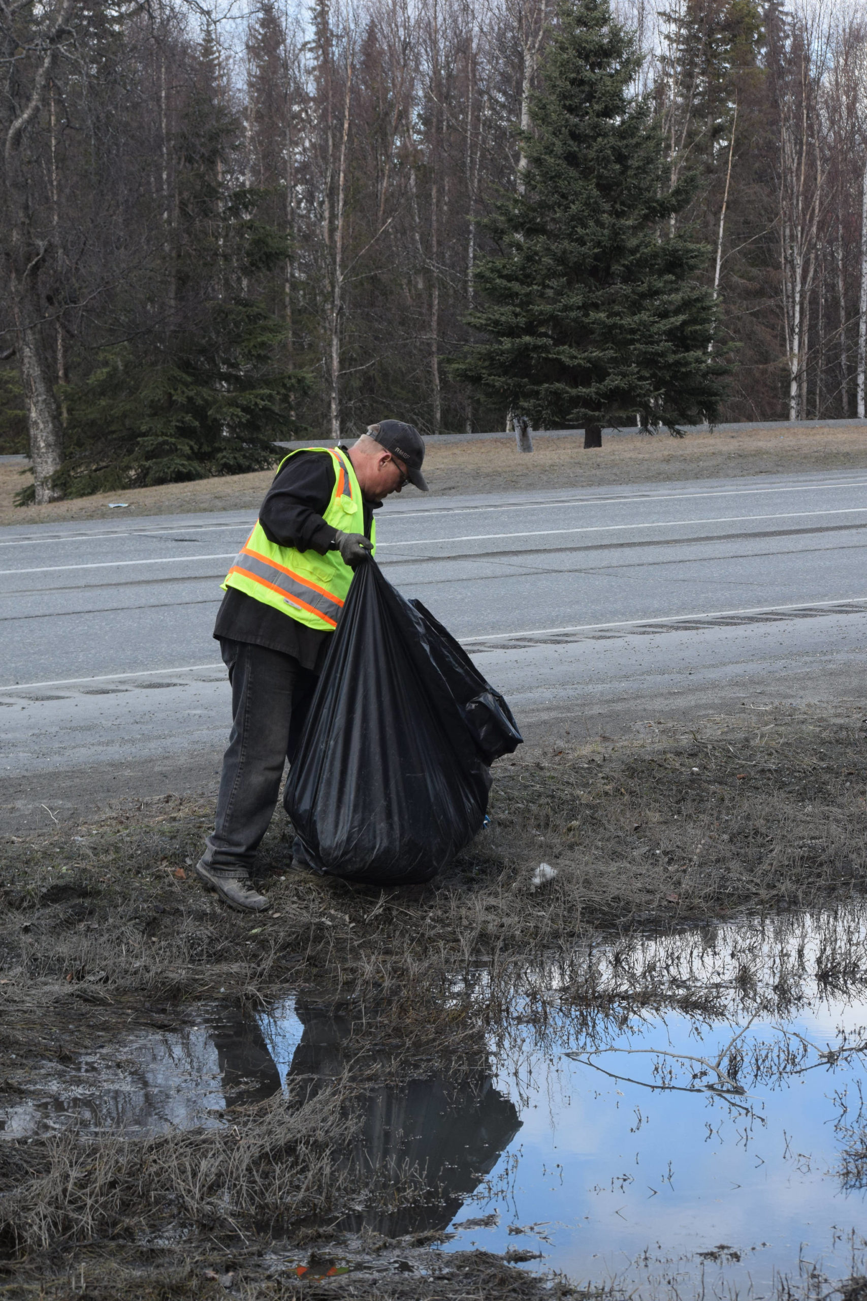 Friends of Alaska National Wildlife Refuge Volunteer Dan Musgrove collects litter from the side of the highway at the refuge in Soldotna, Alaska on Friday, April 30, 2021. (Camille Botello / Peninsula Clarion)