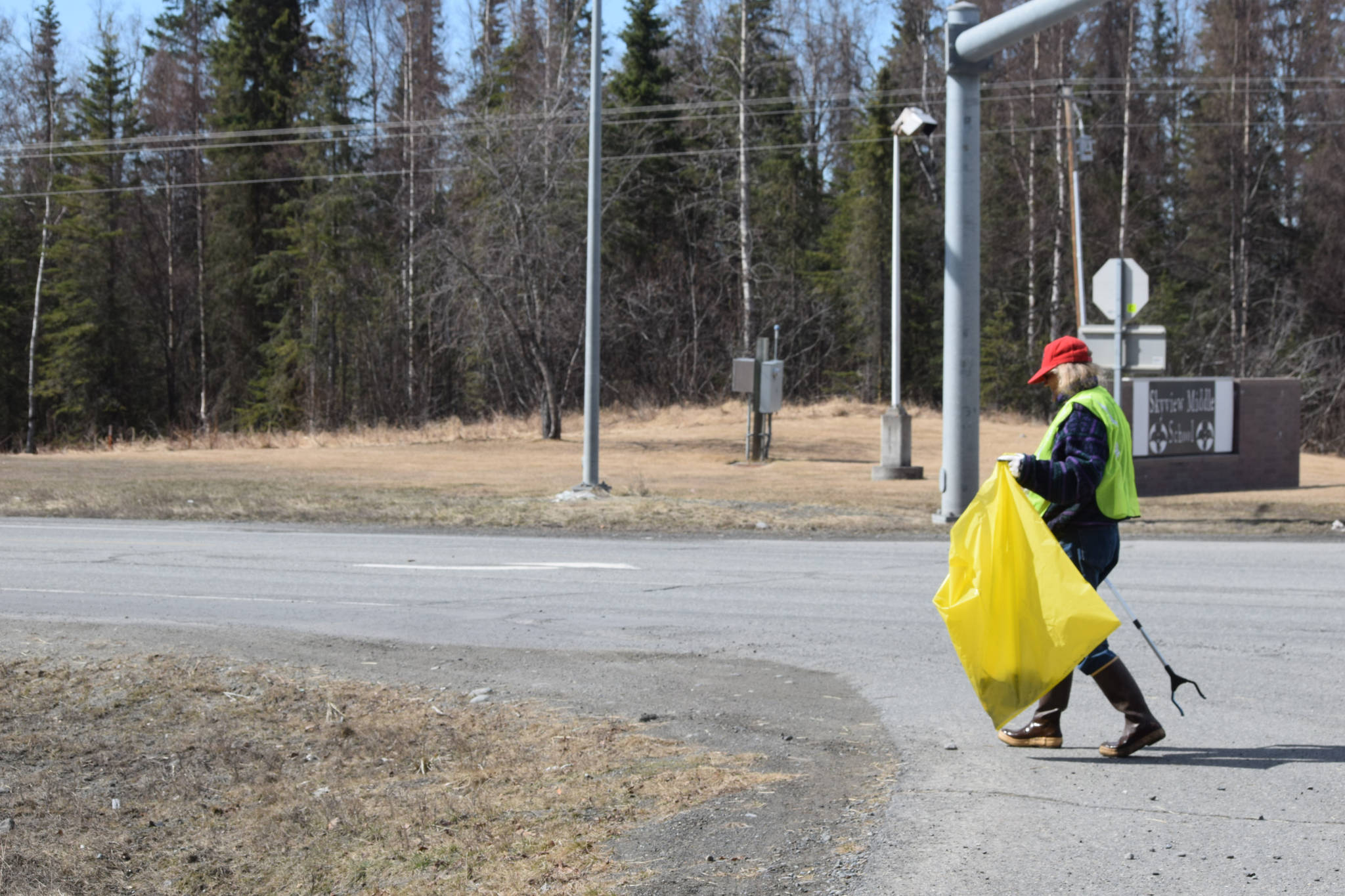 Friends of Alaska National Wildlife Refuge Vice President and Outreach Chair Poppy Benson collects litter from the side of the highway at the refuge in Soldotna, Alaska on Friday, April 30, 2021. (Camille Botello / Peninsula Clarion)