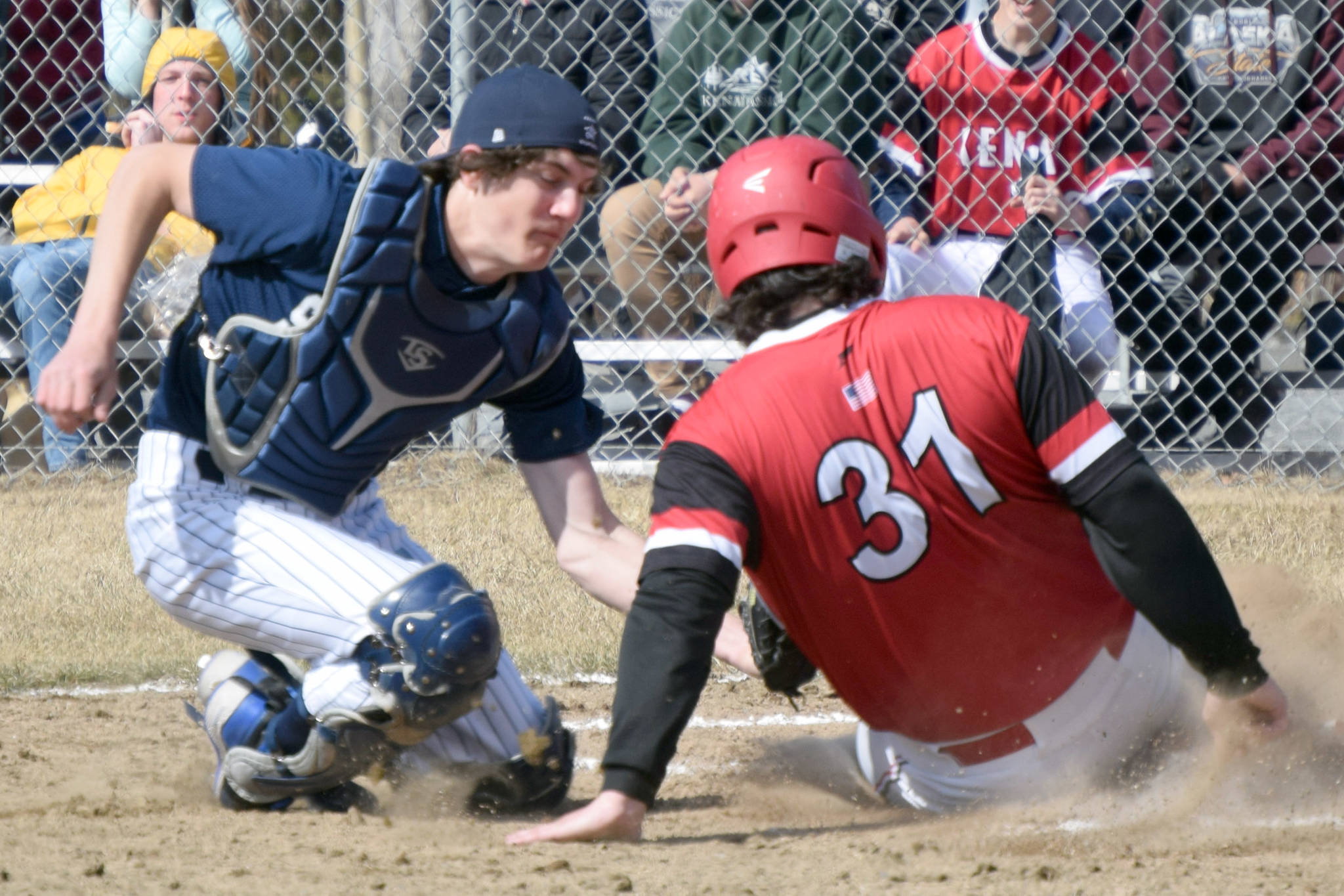 Kenai Central's Jackson DuPerron slides under the tag of Soldotna catcher Jacob Belger on Tuesday, May 4, 2021, at the Soldotna Little League fields in Soldotna, Alaska. (Photo by Jeff Helminiak/Peninsula Clarion)