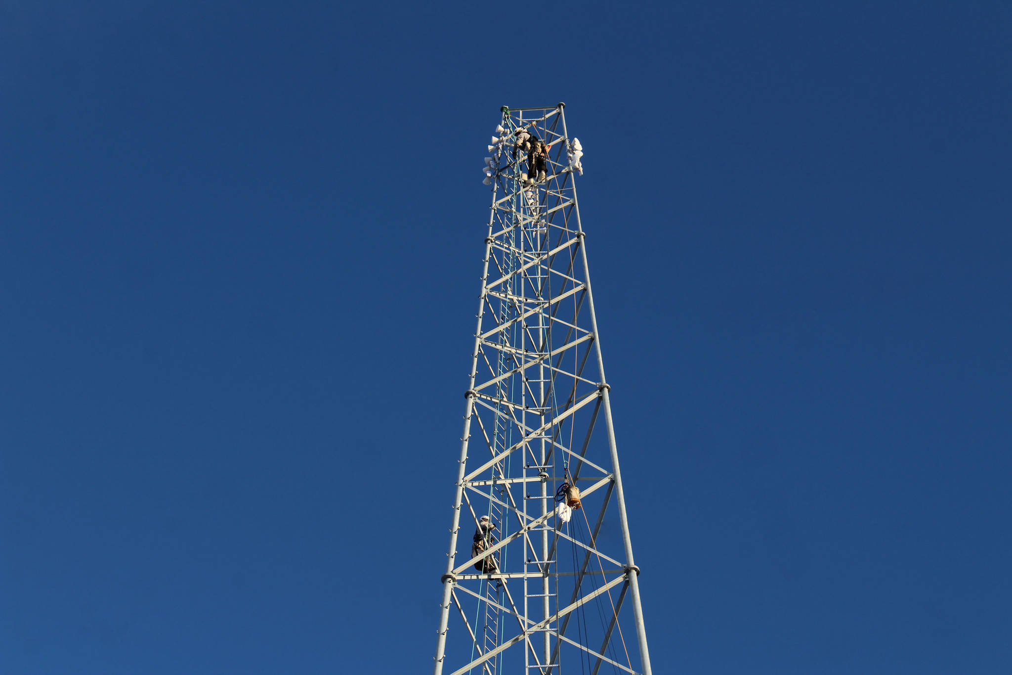 Adam Kiffmeyer and Billy Adamson scale a communications tower on Thursday, Jan. 7 in Nikiski, Alaska. (Ashlyn O’Hara/Peninsula Clarion)