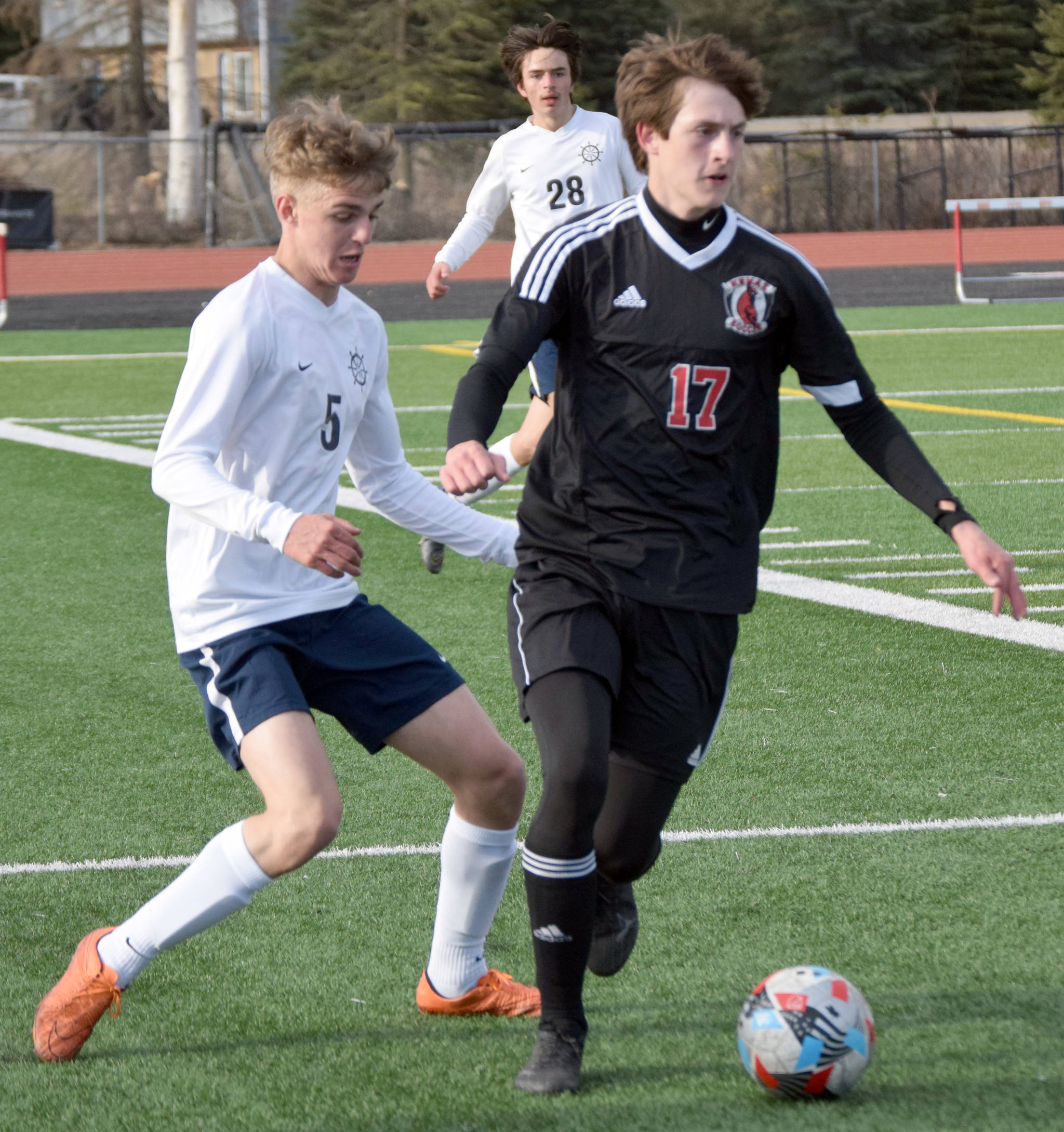 Kenai Central’s Samuel Baisden keeps the ball from Homer’s Austin Cline on Thursday, May 6, 2021, at Kenai Central High School in Kenai, Alaska. (Photo by Jeff Helminiak/Peninsula Clarion)