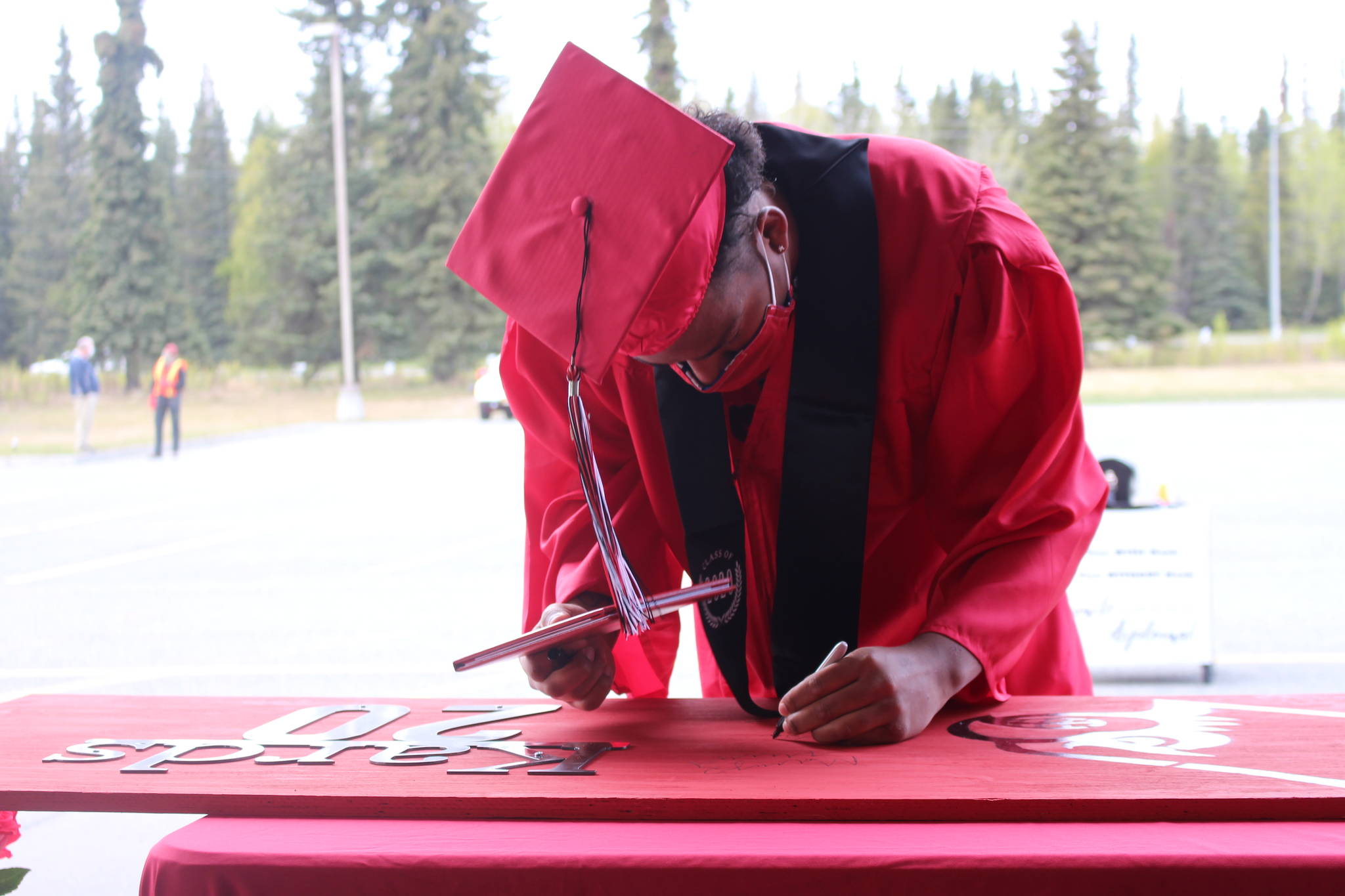 Senior Elijah Royal-Reyna receives his diploma during Kenai Central High School’s Class of 2020 Graduation Parade in Kenai, Alaska on May 20, 2020. (Photo by Brian Mazurek/Peninsula Clarion)