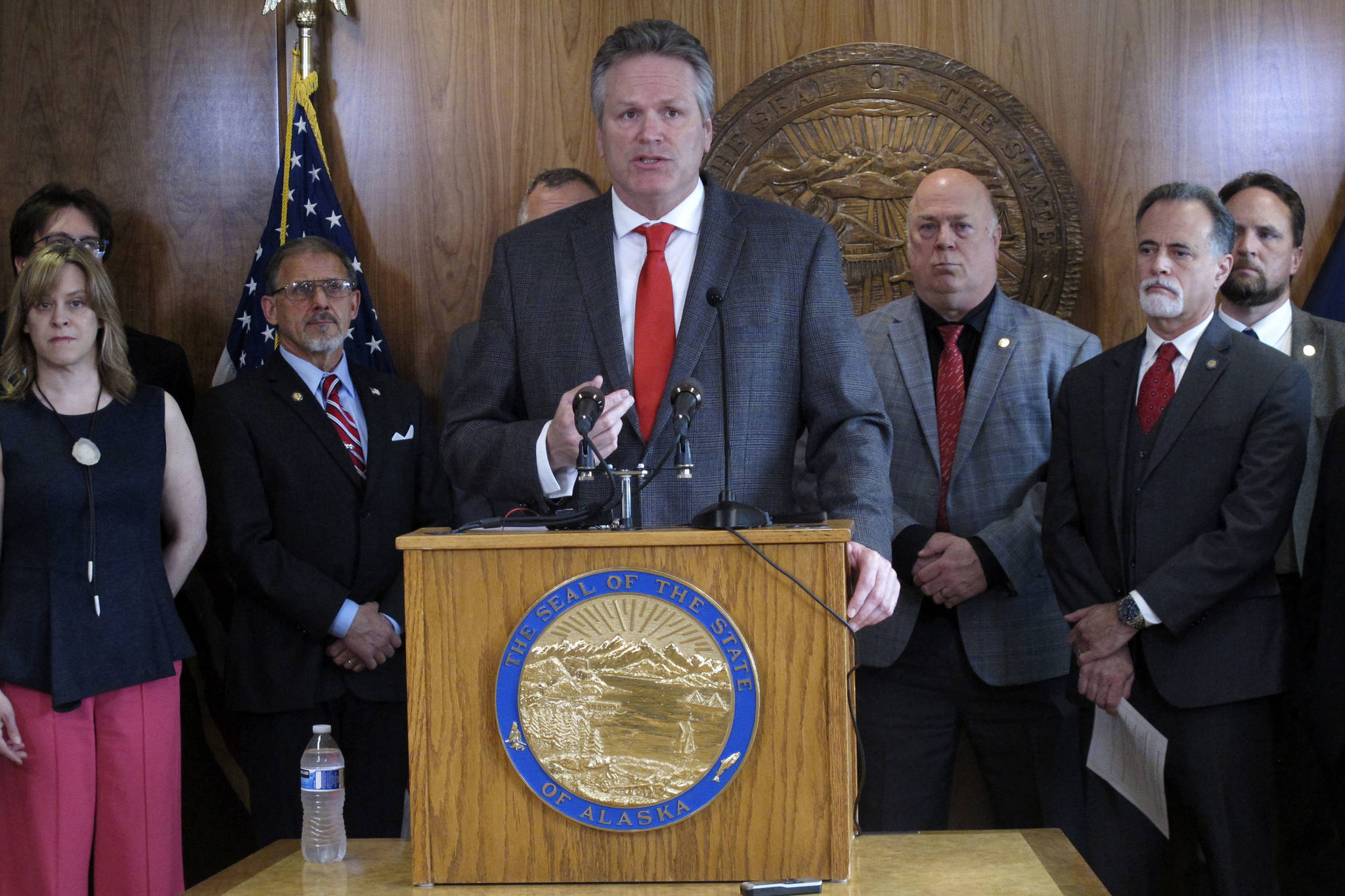 Alaska Gov. Mike Dunleavy speaks during a news conference on Wednesday, May 12, 2021, in Juneau, Alaska, with a number of state legislators around him. Dunleavy discussed a proposed constitutional amendment dealing with the Alaska Permanent Fund and the Permanent Fund dividend. (AP Photo/Becky Bohrer)