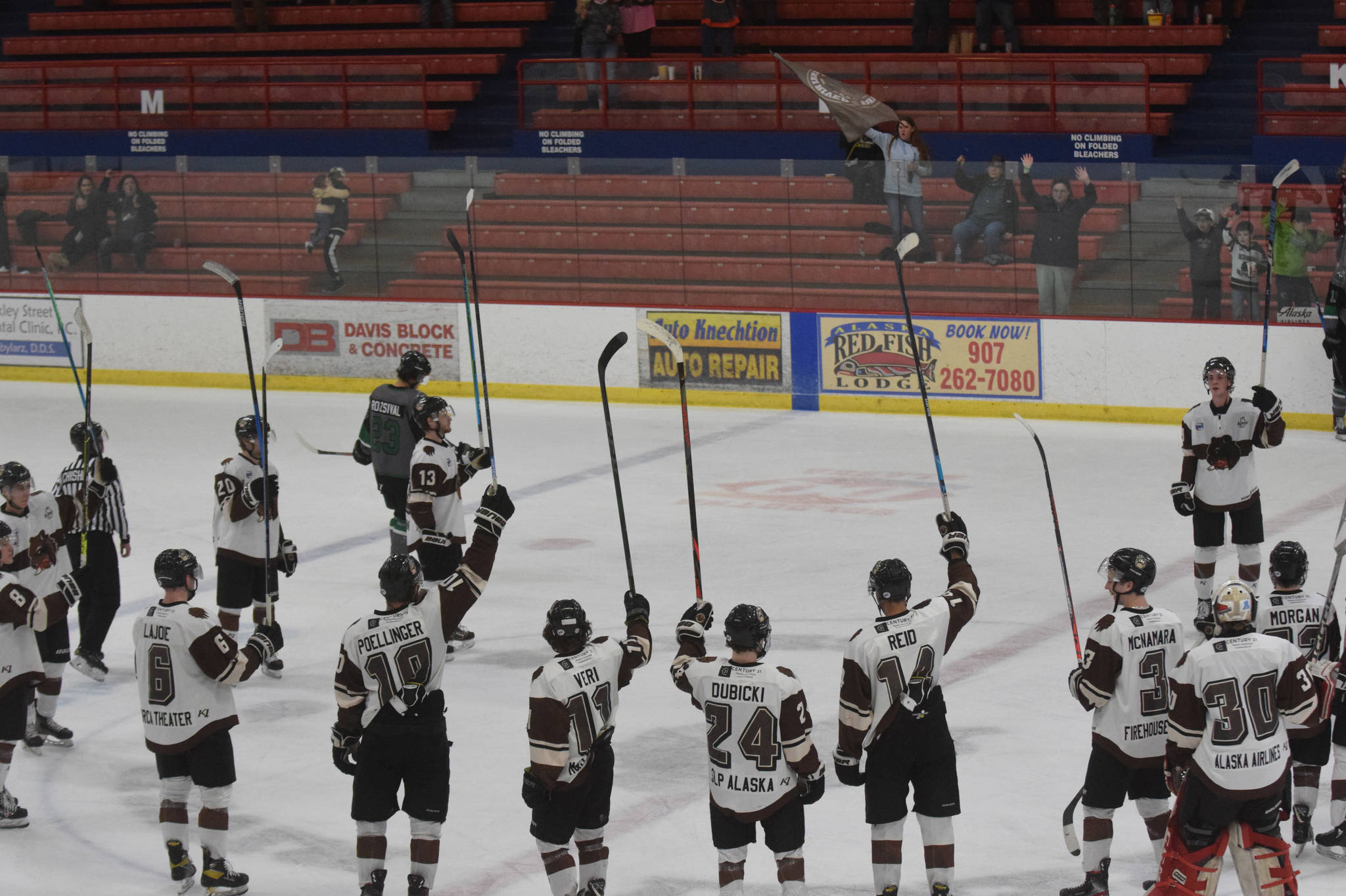The Kenai River Brown Bears salute seats mostly empty due to coronavirus mitigation measures after a victory over the Chippewa (Wisconsin) Steel on Friday, April 23, 2021, at the Soldotna Regional Sports Complex in Soldotna, Alaska. (Photo by Jeff Helminiak/Peninsula Clarion)