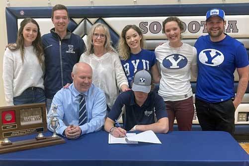 Soldotna senior Dylan Walton signs his National Letter of Intent as his family looks on recently at Soldotna High School in Soldotna, Alaska. (Photo by Jeff Helminiak/Peninsula Clarion)