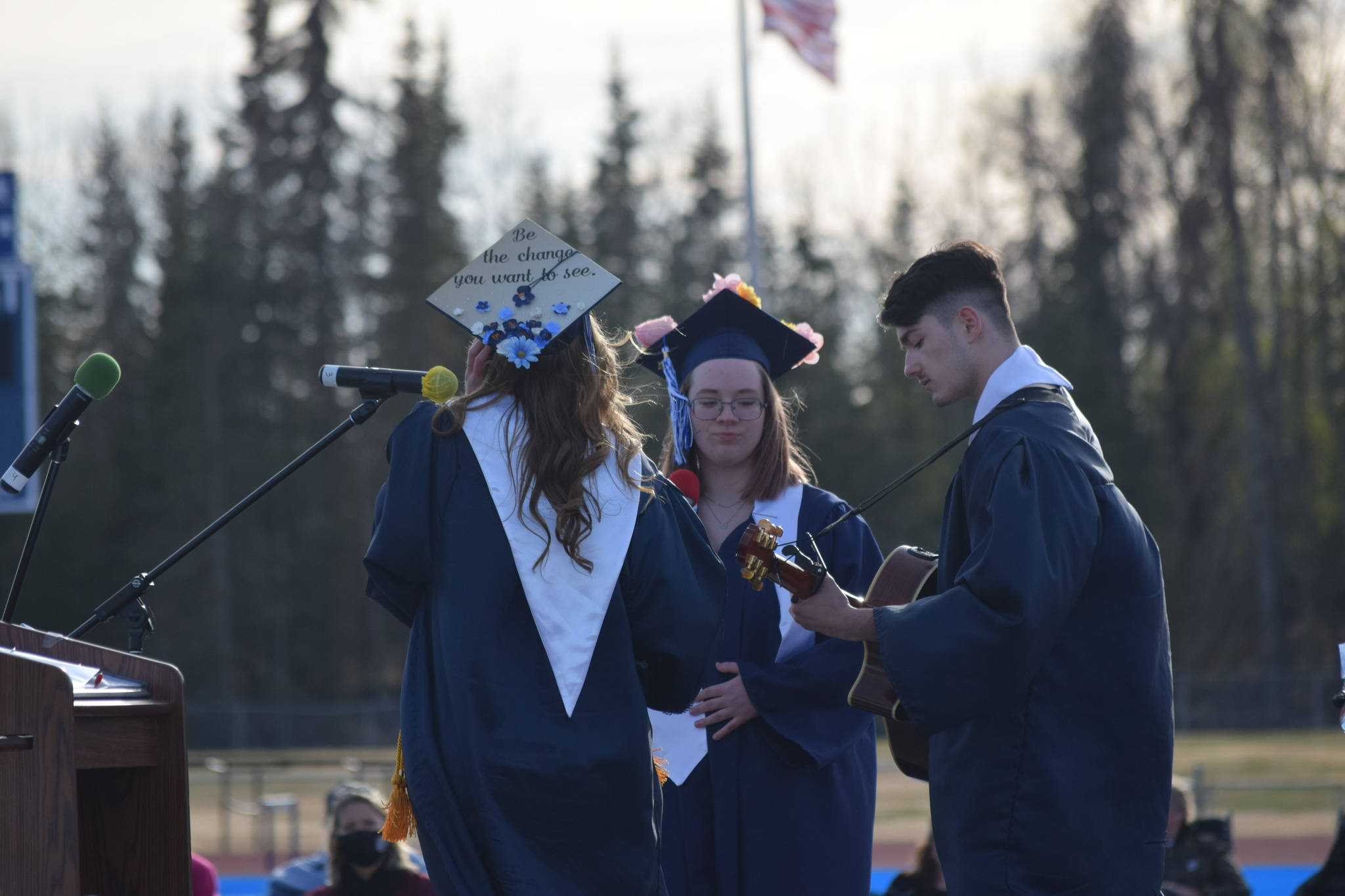 Soldotna High School students Katie Delker, Brittany Lewis and Isaac Nagasako perform at their graduation on Tuesday, May 18, 2021 at the high school football field. (Camille Botello / Peninsula Clarion)