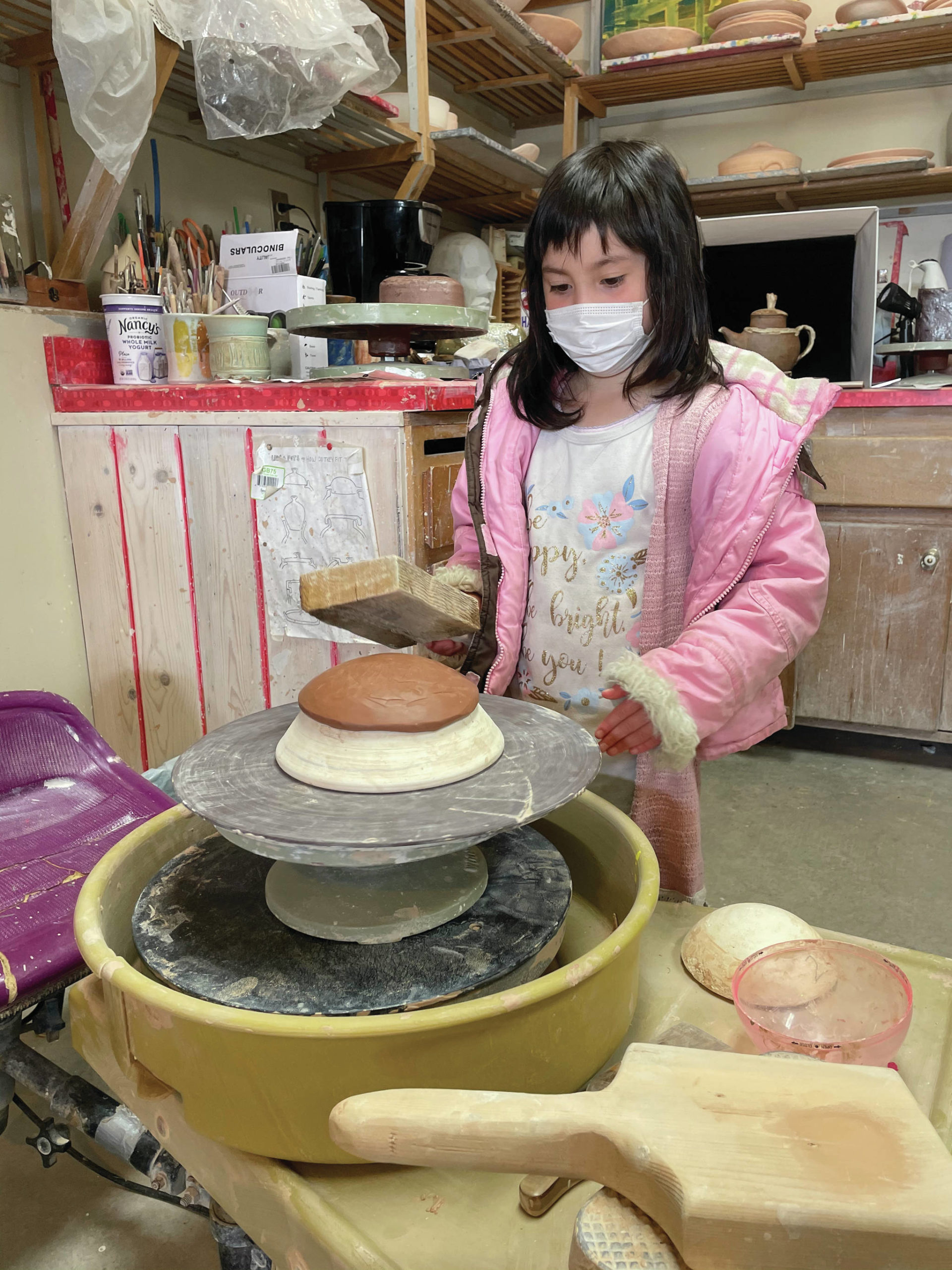 A little visitor at the Jars of Clay studio gets hands-on with the paddle pot demonstration on Saturday, May 15, 2021, at the studio in Homer, Alaska. (Photo by Tara Schmidt)