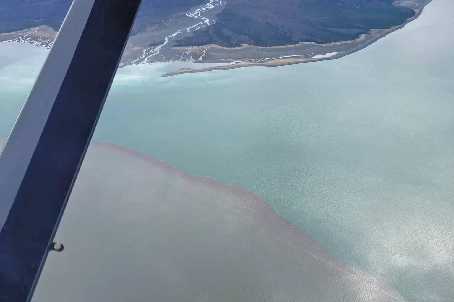 This photo taken Beryl Air pilot Stephanie Greer on Friday, May 21, over Grewingk Glacier and Glacier Spit shows the mesodinium rubrum bloom to the left as contrasted with the normal ocean water of Kachemak Bay near Homer. (Photo courtesy of Stephanie Greer/Beryl Air)