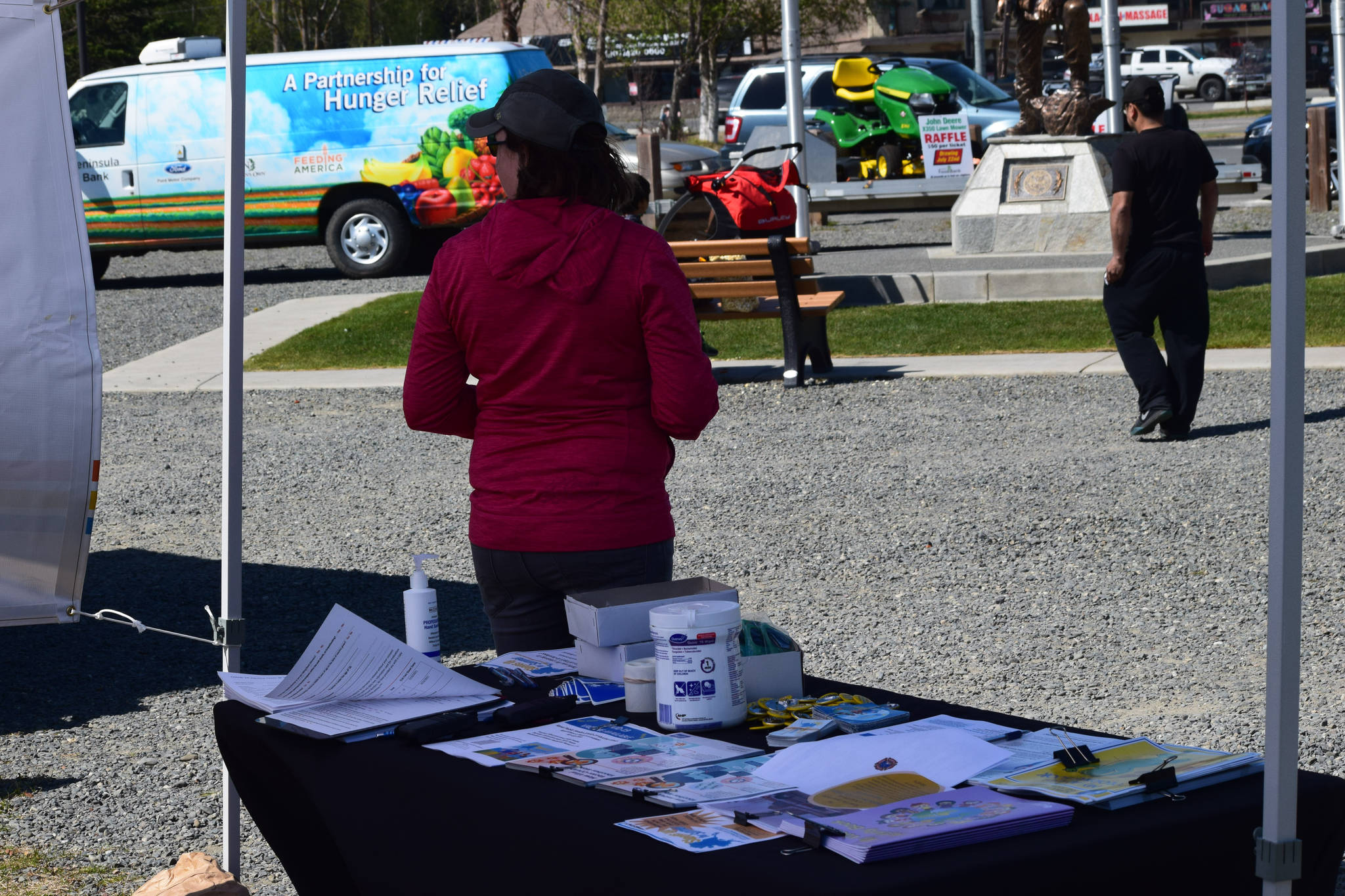 A nurse with Kenai Public Health encourages people to get their COVID-19 vaccines during the first day of the Wednesday Market in Soldotna, Alaska, on Wednesday, May 26, 2021. (Camille Botello / Peninsula Clarion)