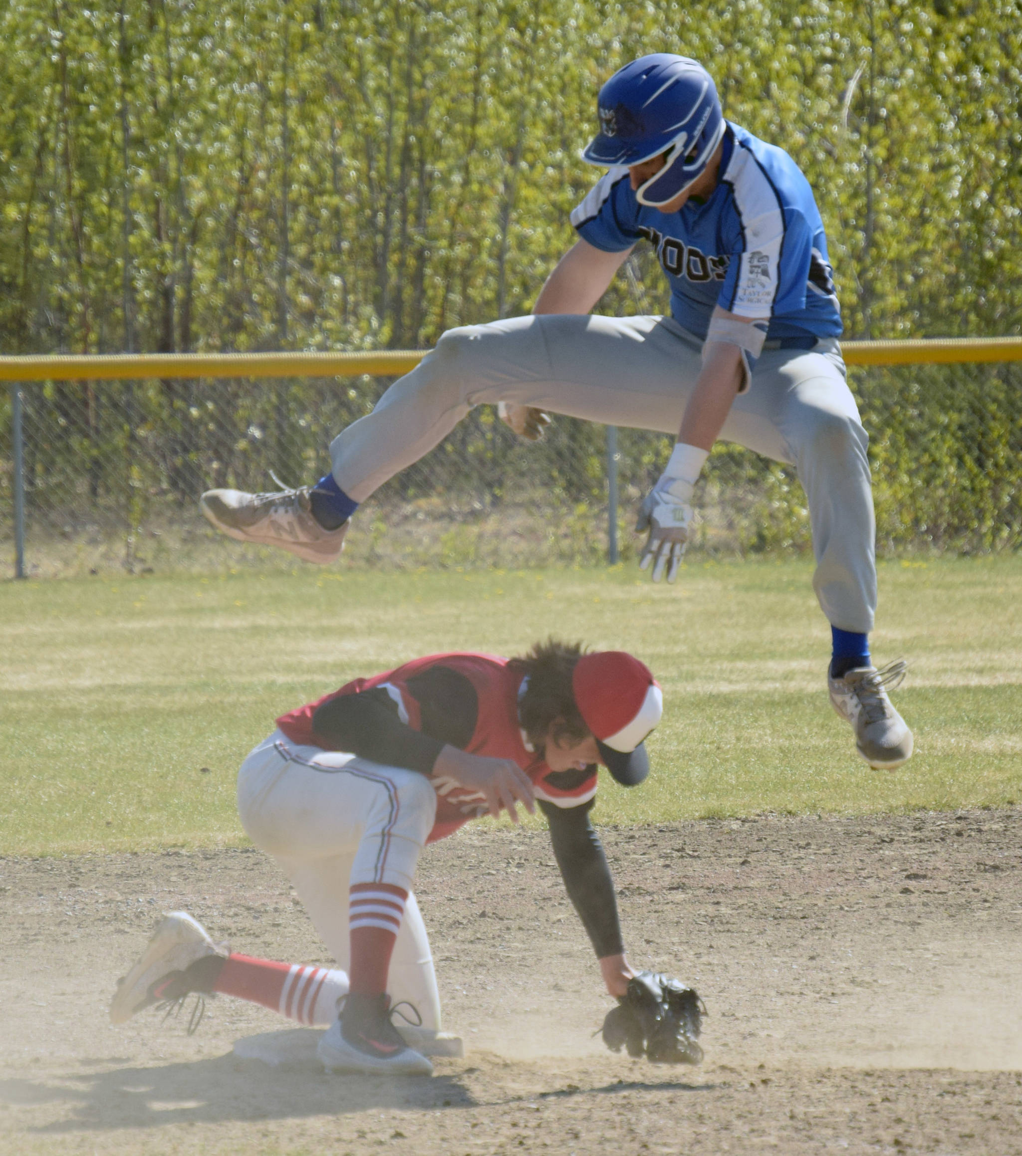 Palmer’s Owen Hayes jumps over Kenai pitcher Simon Grenier. Hayes was able to take third base safely for a triple Thursday, May 27, 2021, at the Southcentral Conference tournament at the Soldotna Little League fields in Soldotna, Alaska. (Photo by Jeff Helminiak/Peninsula Clarion)