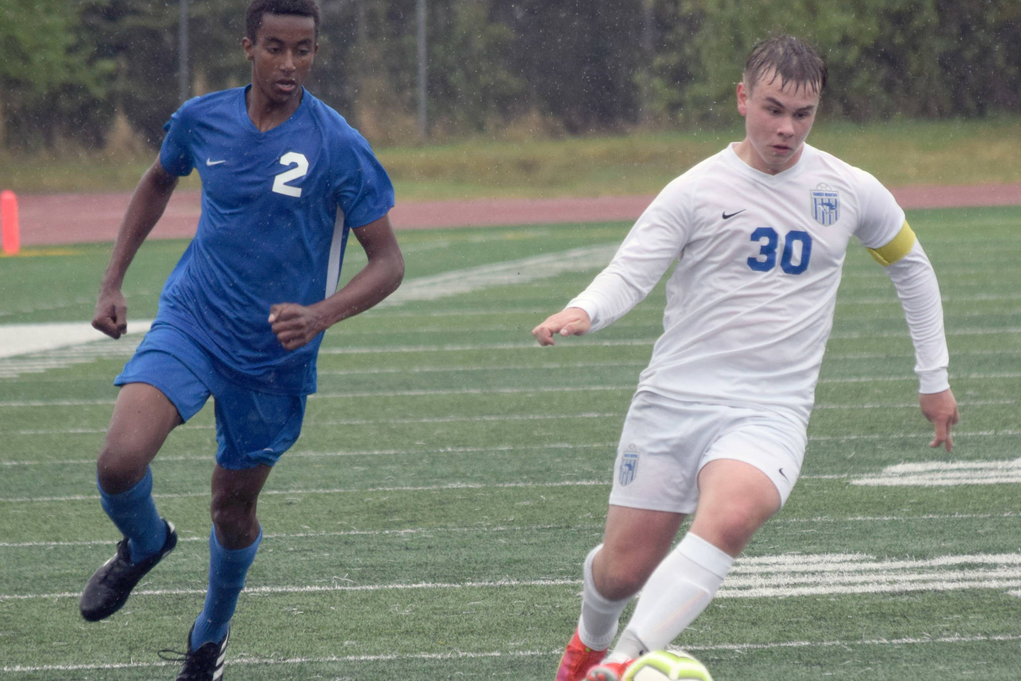 Soldotna's Maleda Denbrock runs to defend Thunder Mountain's Logan Miller at the Division II state championship game in Anchorage, Alaska, on Saturday, May 29, 2021. (Photo by Camille Botello/Peninsula Clarion)