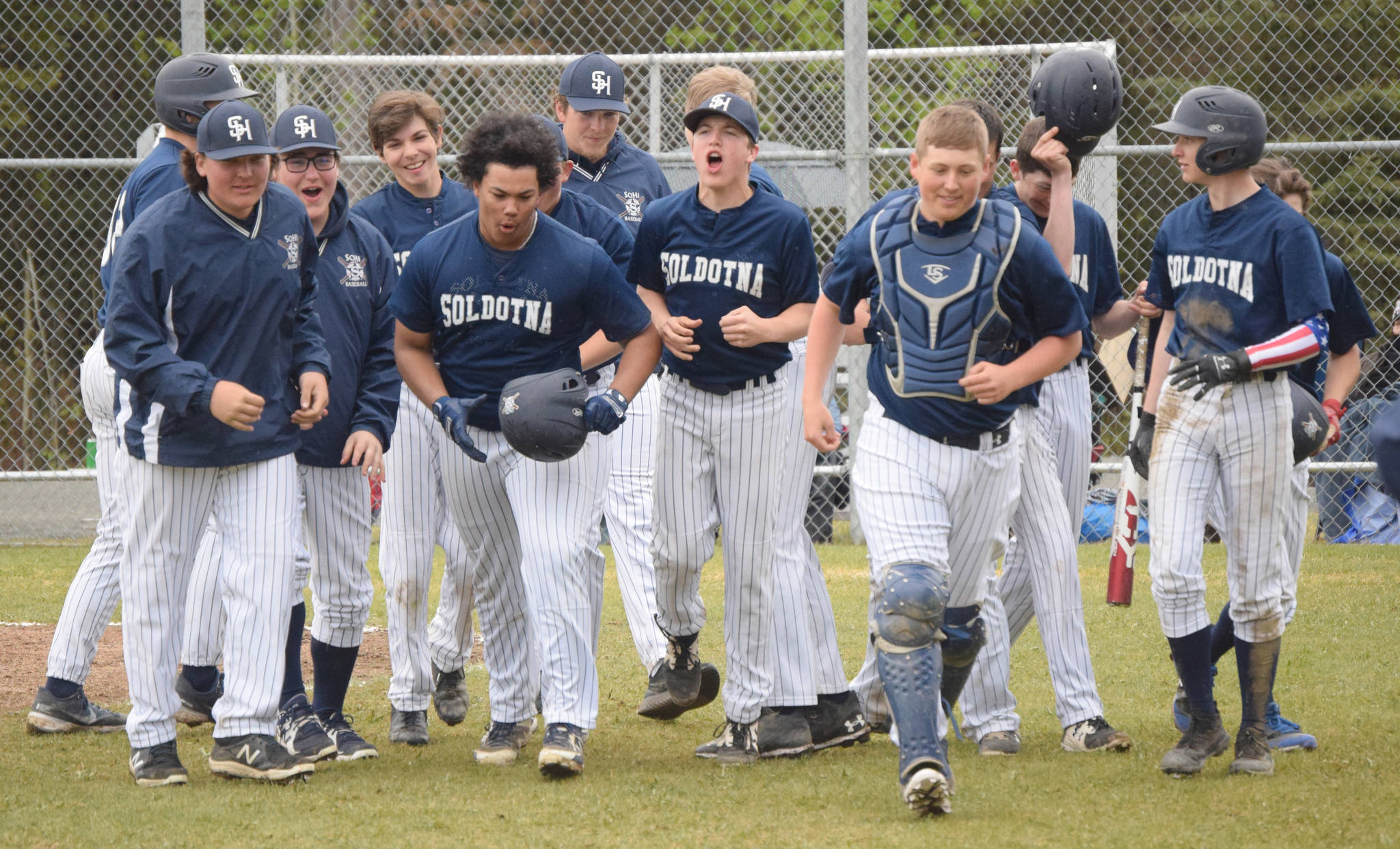Soldotna players congratulate Atticus Gibson (center, helmet in hand) on his grand slam in the second inning against Homer on Saturday, May 29, 2021, at the Southcentral Conference tournament at the Soldotna Little League fields in Soldotna, Alaska. (Photo by Jeff Helminiak/Peninsula Clarion)