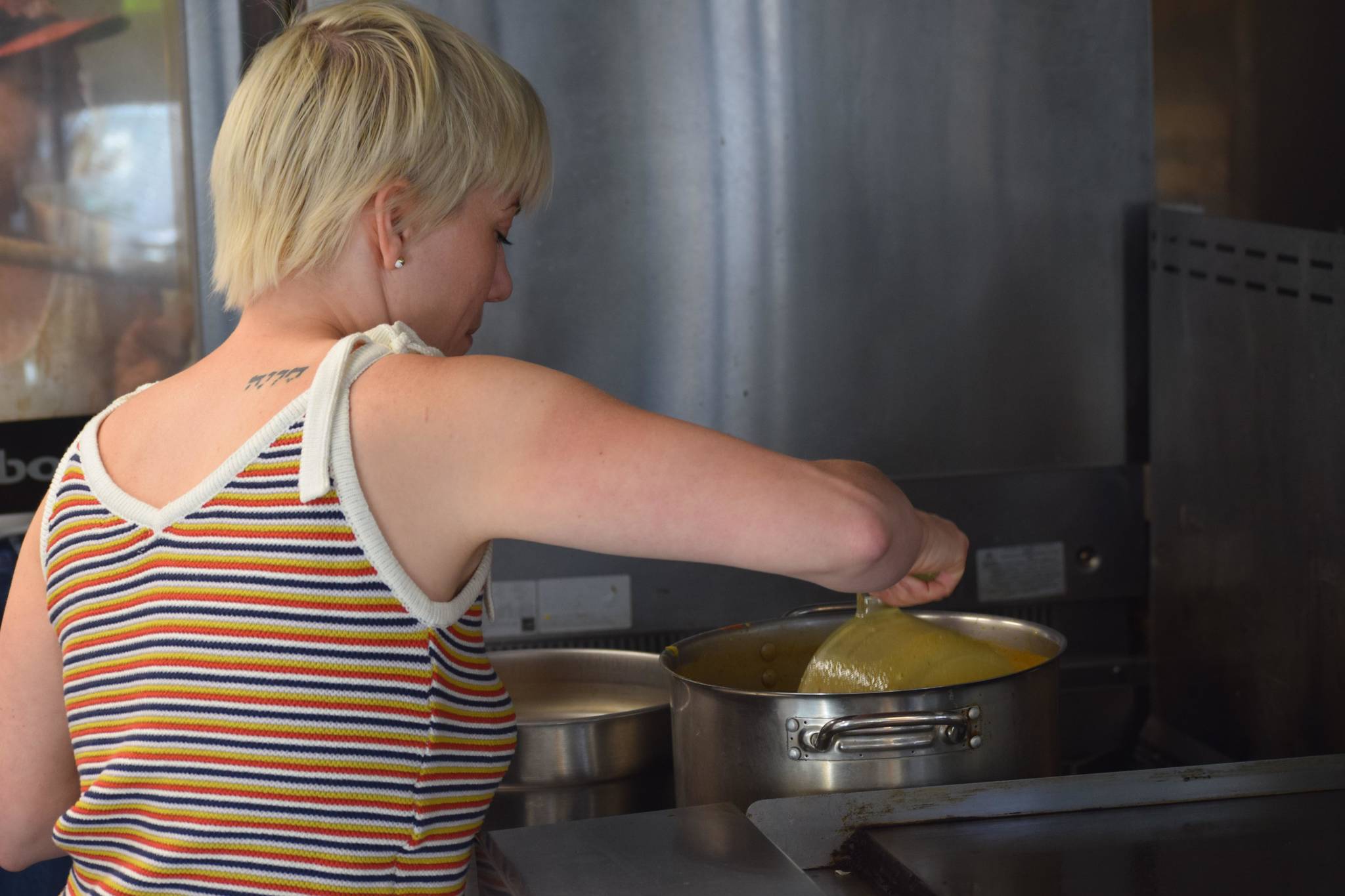 Lucy’s Market Owner Kelsey Shields prepares soup of the day at the shop in Soldotna, Alaska, on Wednesday, May 26, 2021. (Camille Botello/Peninsula Clarion)