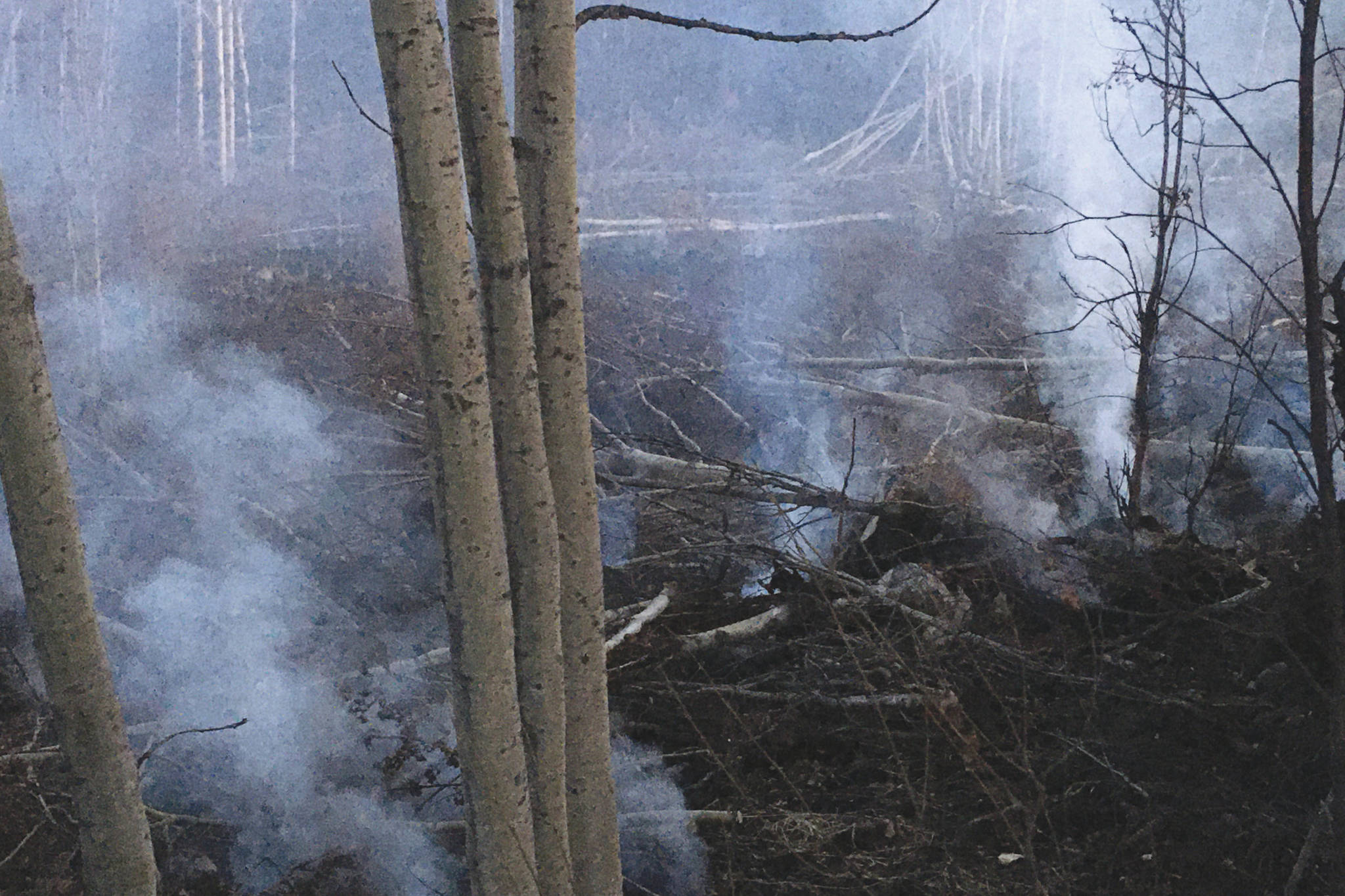 Smoke can be seen rising from areas scarred by the Swan Lake Fire on Sunday, Oct. 6, 2019 at Mile 10 of Skilak Loop Road, on Alaska’s Kenai Peninsula. (Photo by Jeff Helminiak/Peninsula Clarion)