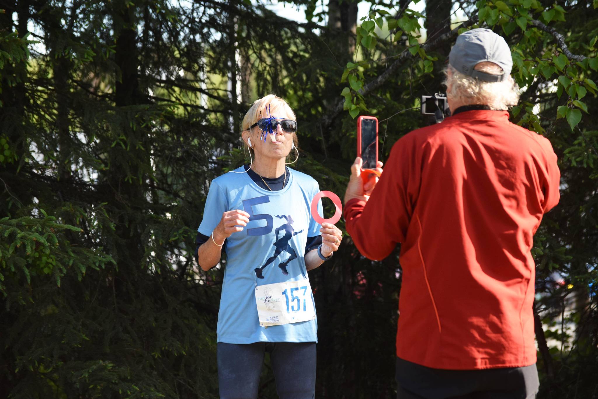 Susie Pline finishes her 50th run in her 50th state at the Kenai Watershed Forum’s Run for the River in Soldotna Creek Park on Saturday, June 12, 2021. (Camille Botello/Peninsula Clarion)