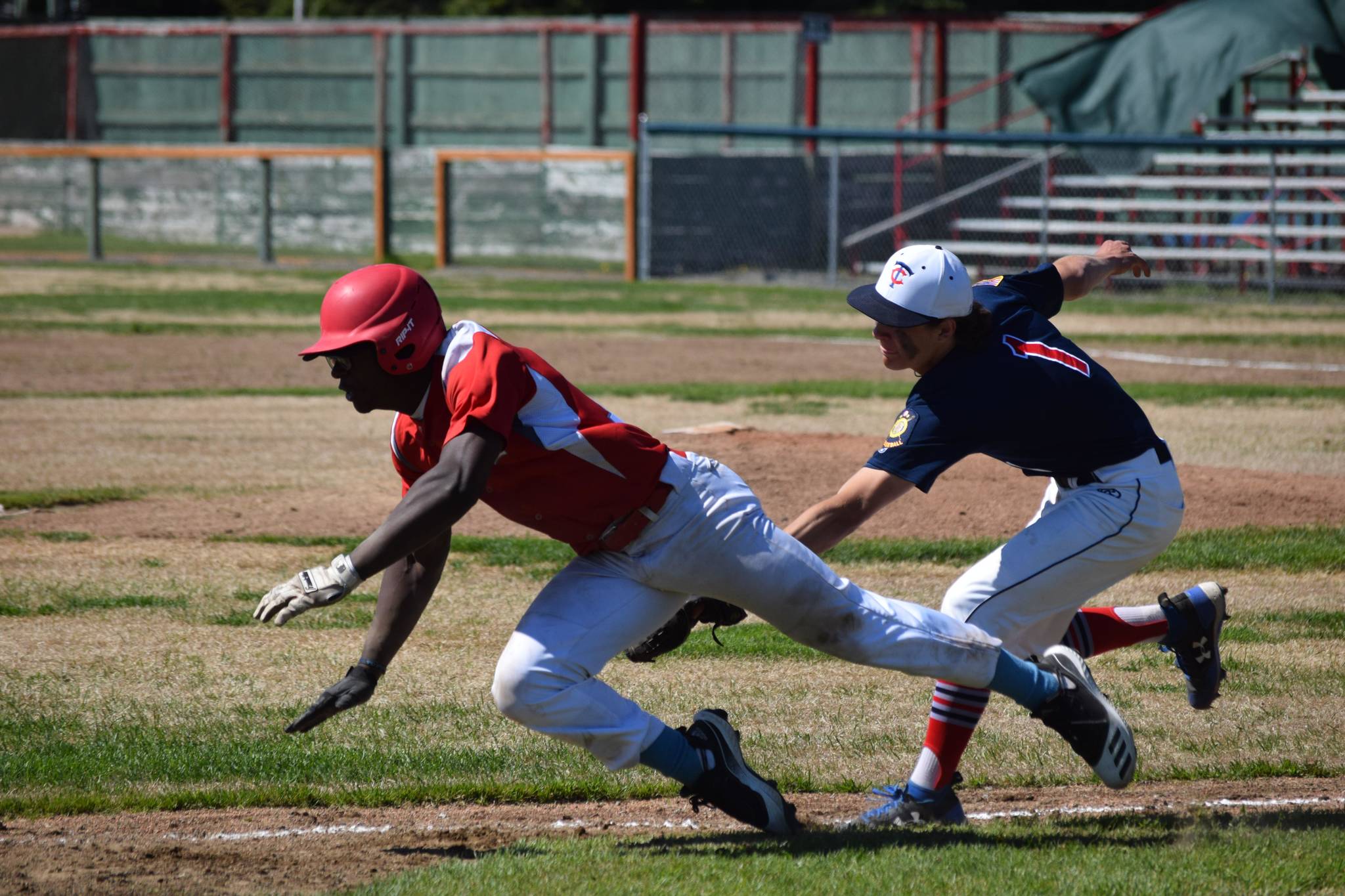 Jacob Belger tags an East Anchorage base runner out in a run-down for the final out of the game at Oiler Park on Sunday, June 13, 2021, securing the first league win for the Kenai Twins. (Camille Botello / Peninsula Clarion)