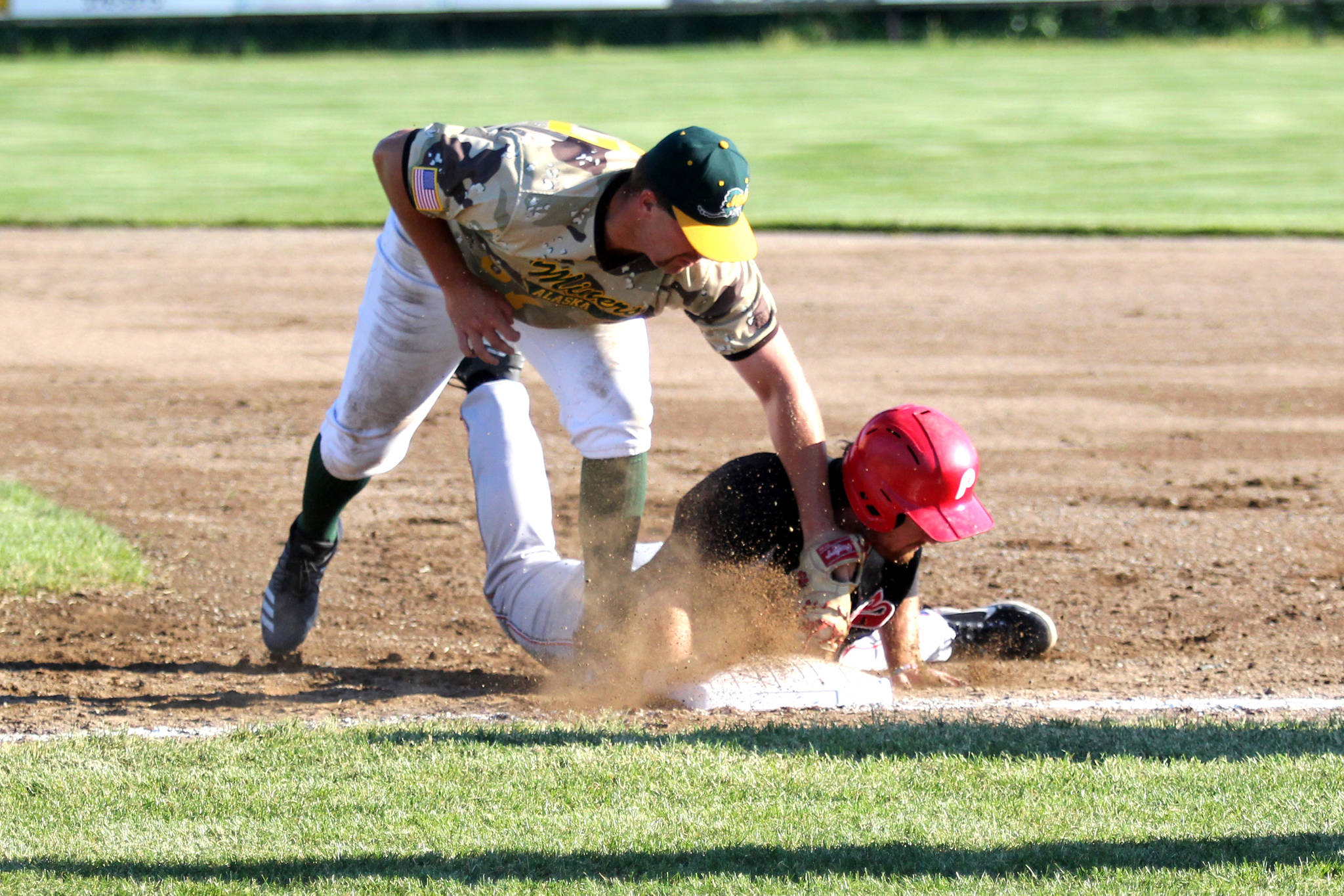 Peninsula Oilers first baseman John Hanley beats the tag of Mat-Su Miners first baseman Nick Cirelli during Mat-Su’s 5-2 win over the Oilers Monday, June 14, 2021, at Hermon Brothers Field in Palmer. (Jeremiah Bartz/Frontiersman)