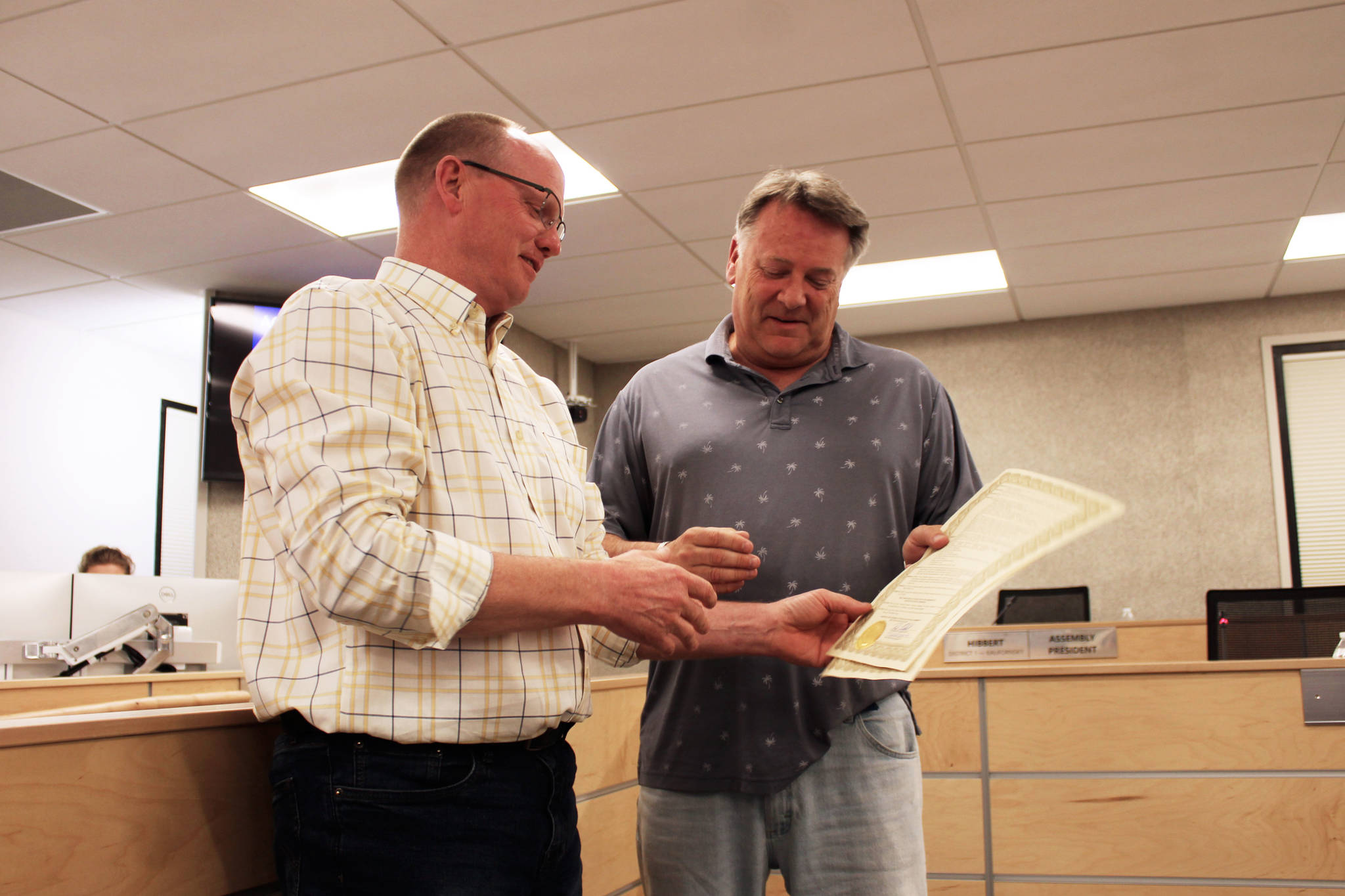 Brent Hibbert (left) presents Tim Dillon (right) with a commending resolution on Tuesday, June 15, 2021 in Soldotna, Alaska. (Ashlyn O’Hara/Peninsula Clarion)