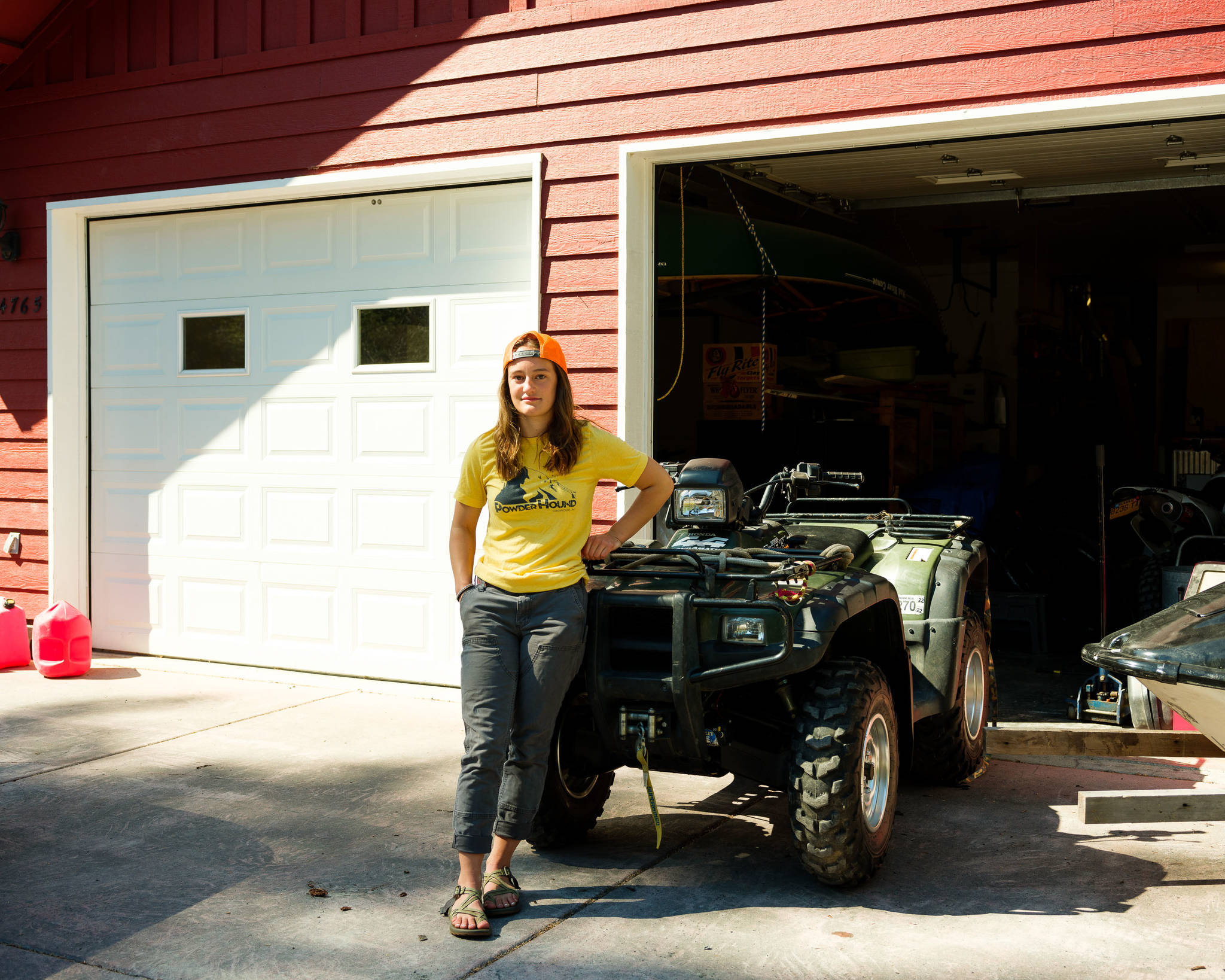 Seward High School student Annika Nilsson, 17, stands next to her family’s all terrain vehicle, which is one of the only vehicles that can be used when her neighborhood roads flood every autumn. (Young Kim for The Hechinger Report)