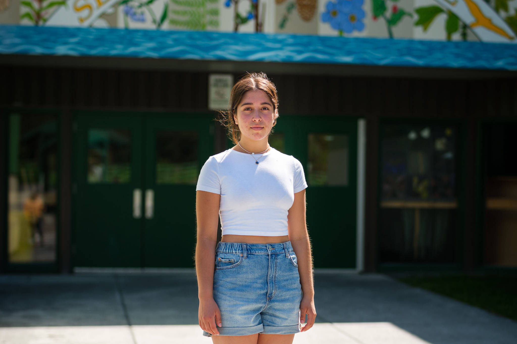 Selma Casagranda, a recent Seward High School graduate and lifelong resident of Seward, stands in front of her former school on May 25, 2021. (Young Kim for The Hechinger Report)