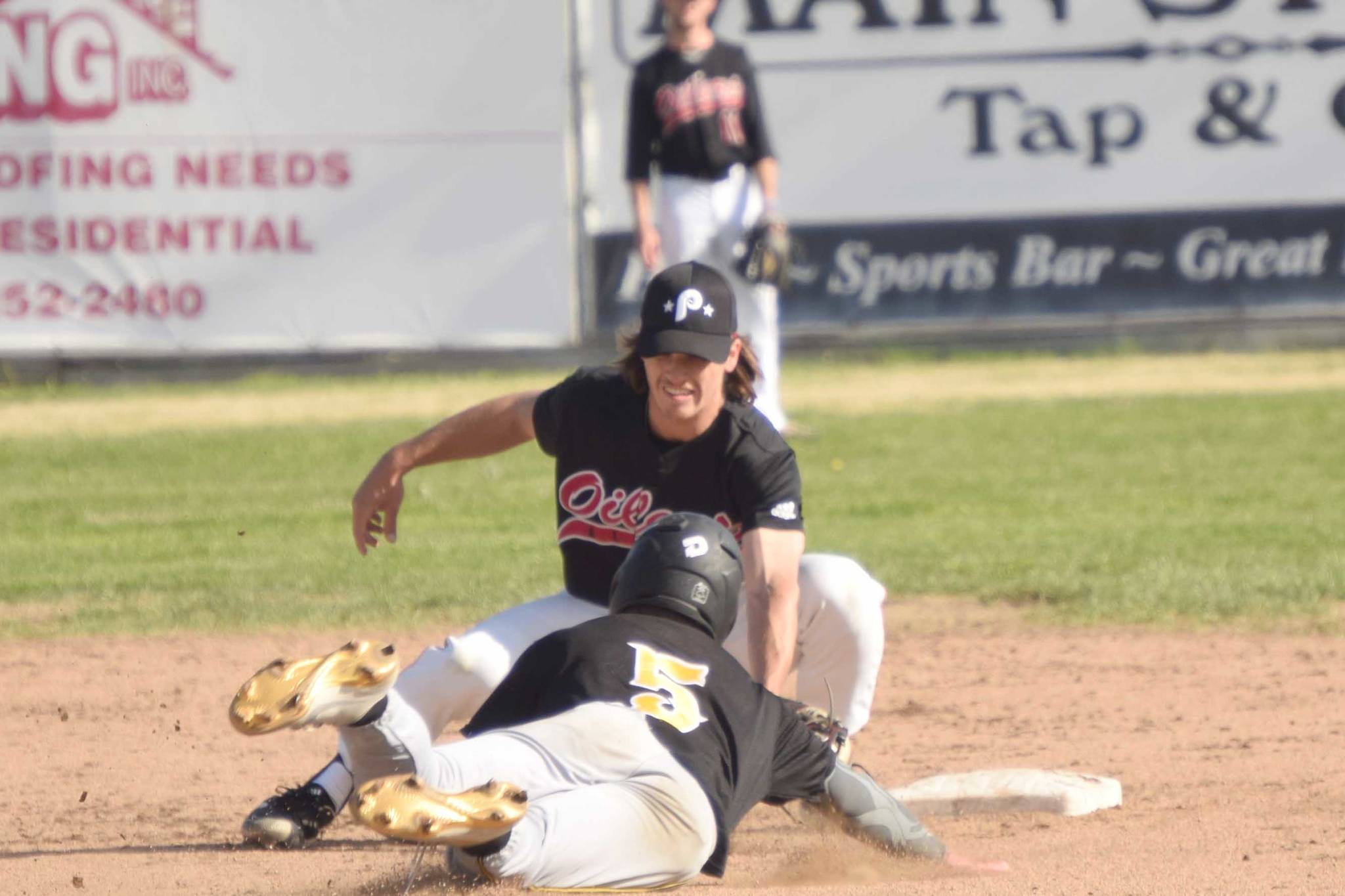 Peninsula Oilers shortstop Trevor Antonson tags out Garrett Ostrander of the Anchorage Bucs on a steal attempt Monday, June 28, 2021, at Coral Seymour Memorial Park in Kenai, Alaska. (Photo by Jeff Helminiak/Peninsula Clarion)
