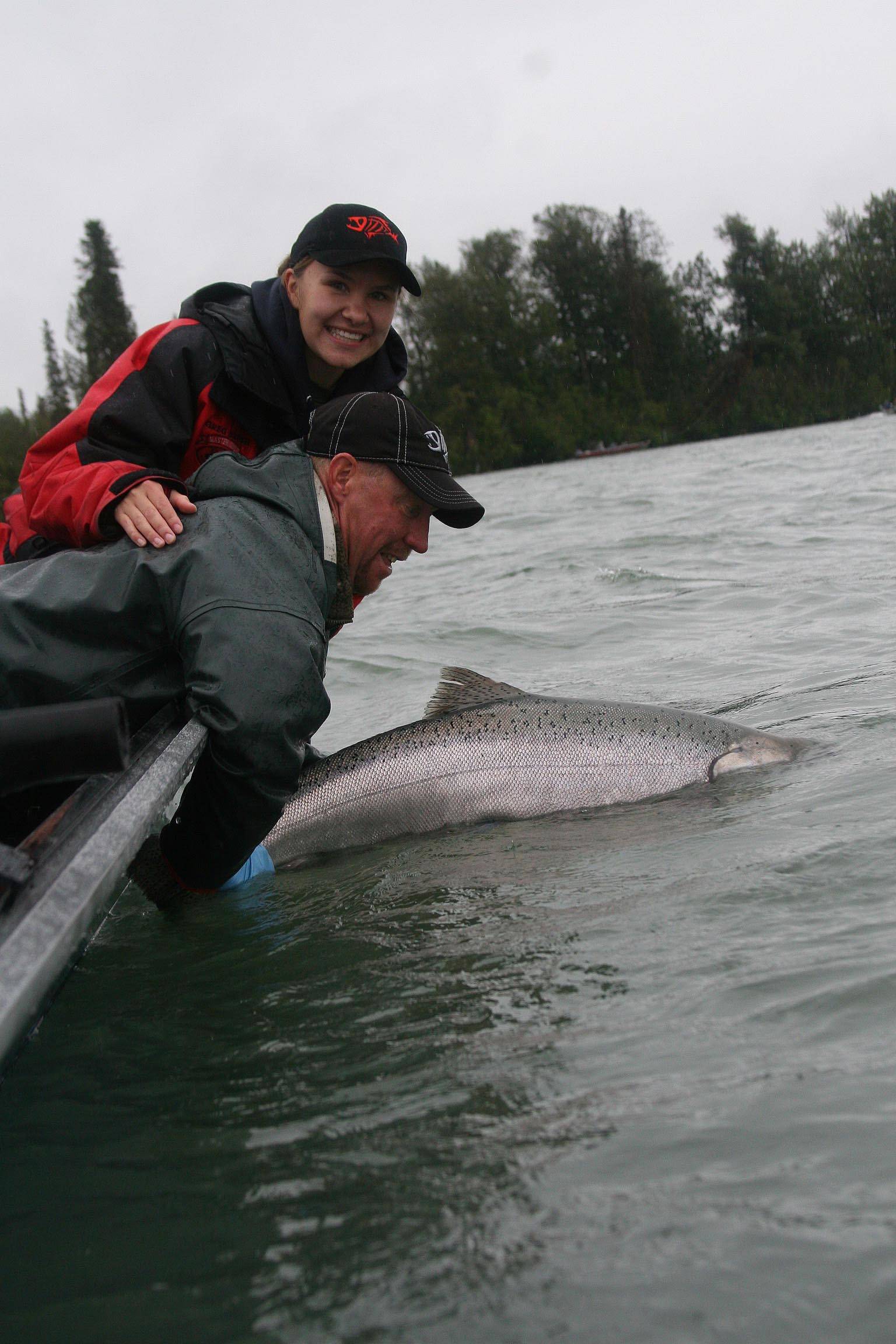 Greg Brush, center, passes Kenai conservation on to the next generation of anglers by releasing a king salmon. (Photo courtesy Greg Brush)