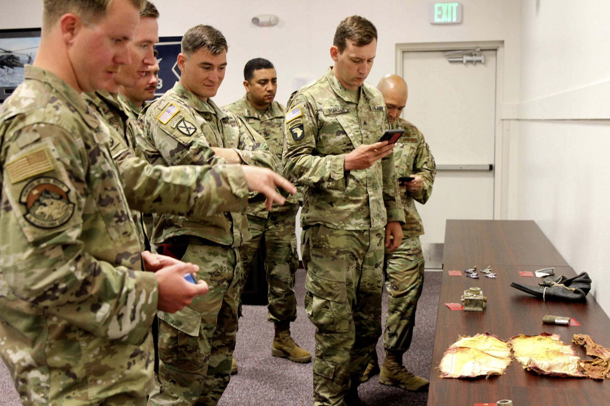 Alaska-based military members who participated in a search for human remains and personal items from the 1952 crash of a C-124 Globemaster view some of the items that were found, Tuesday, Sept. 29, 2021, at Joint Base Elmendorf-Richardson, Alaska. (AP Photo/Mark Thiessen)