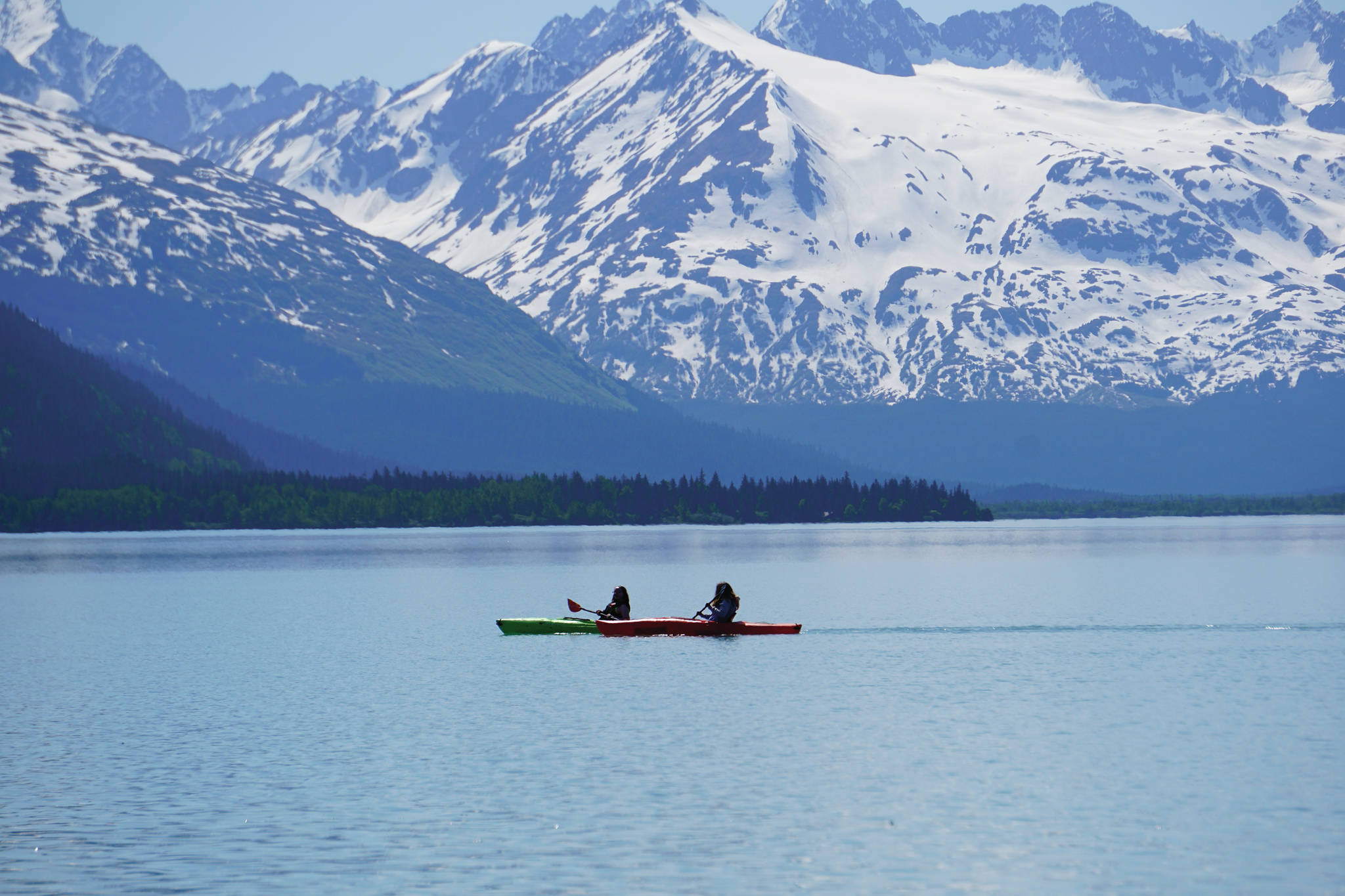 Kayakers paddle across Kenai Lake on Saturday, June 12, 2021, near Seward, Alaska. (Photo by Michael Armstrong/Homer News)