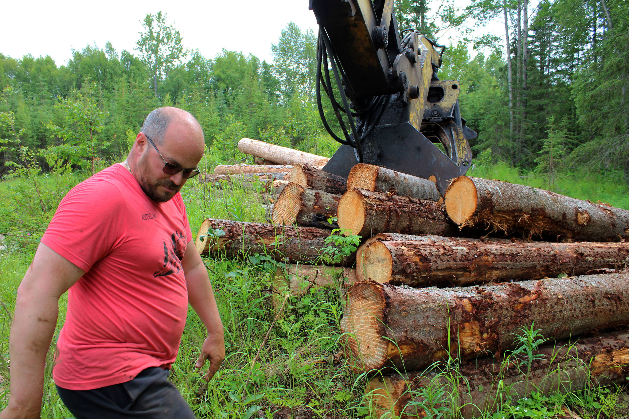 Walt Blauvelt stands by logs near the Central Peninsula Landfill on Thursday, July 1, 2021 near Soldotna, Alaska. (Ashlyn O’Hara/Peninsula Clarion)