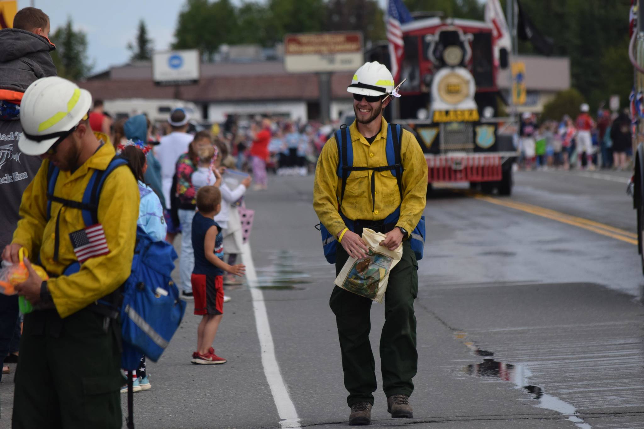 Officials with the Smokey Bear float hand out bracelets during Kenai’s annual Fourth of July parade on July 4, 2021. (Camille Botello / Peninsula Clarion)