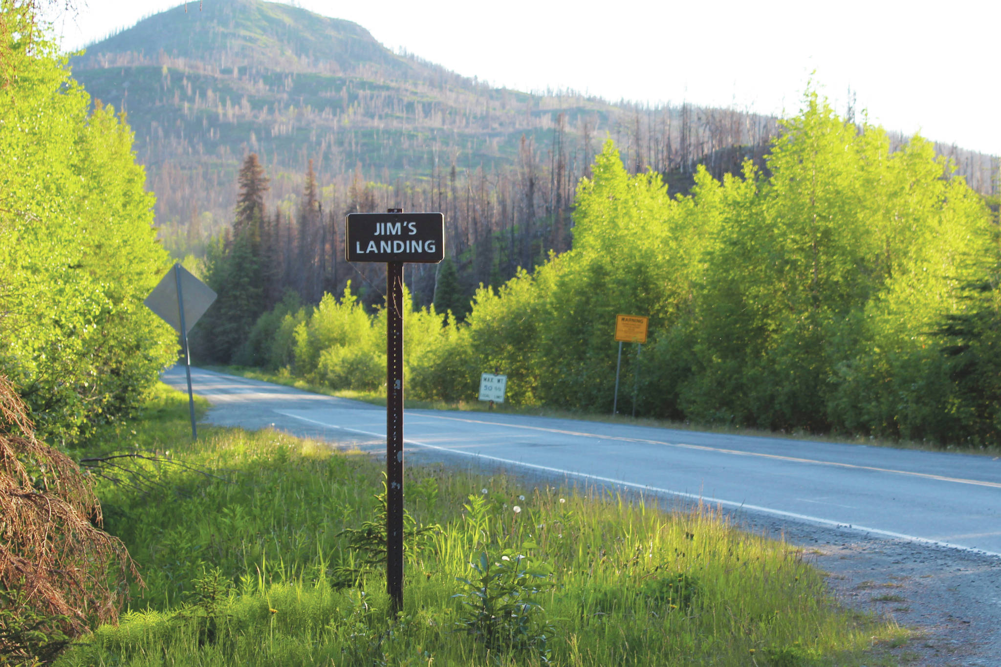 A sign indicates the turn for Jim’s Landing on Skilak Lake Road on Sunday, June 13, 2021 near Skilak Lake on the Kenai Peninsula in Alaska. (Ashlyn O’Hara/Peninsula Clarion)
