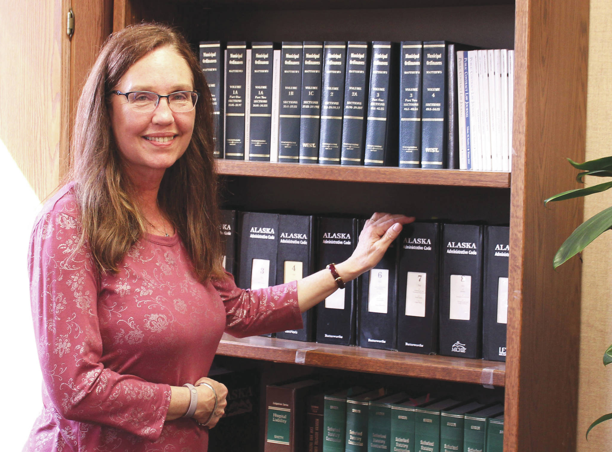 Ashlyn O’Hara / Peninsula Clarion
Colette Thompson stands near a bookshelf in her office Thursday at the George A. Navarre Borough Building in Soldotna.