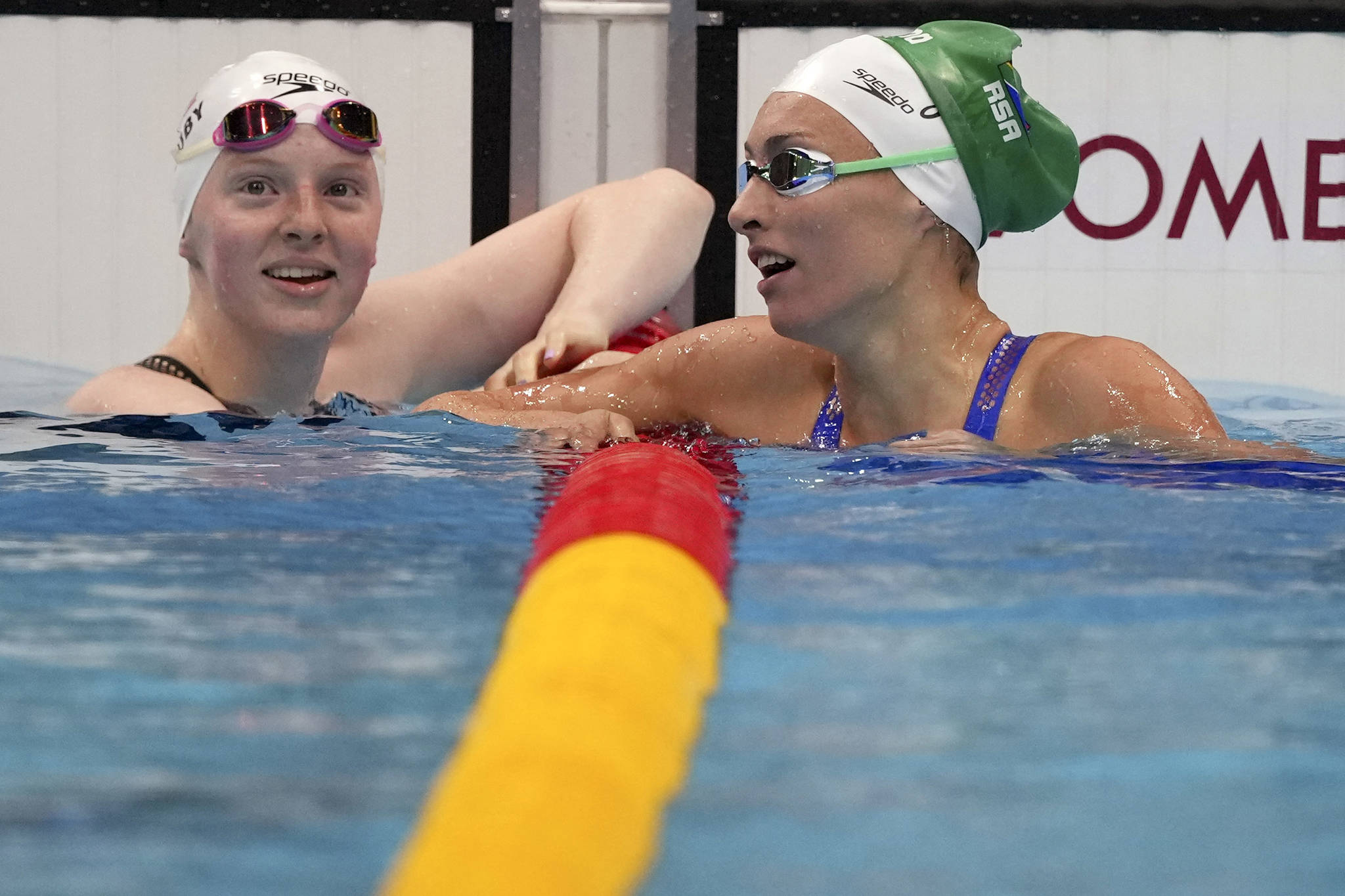 Lydia Jacoby, left, of the United States congratulates Tatjana Schoenmaker of South Africa after their heat in the women’s 100-meter breaststroke at the 2020 Summer Olympics, Sunday, July 25, 2021, in Tokyo, Japan. (AP Photo/Matthias Schrader)
