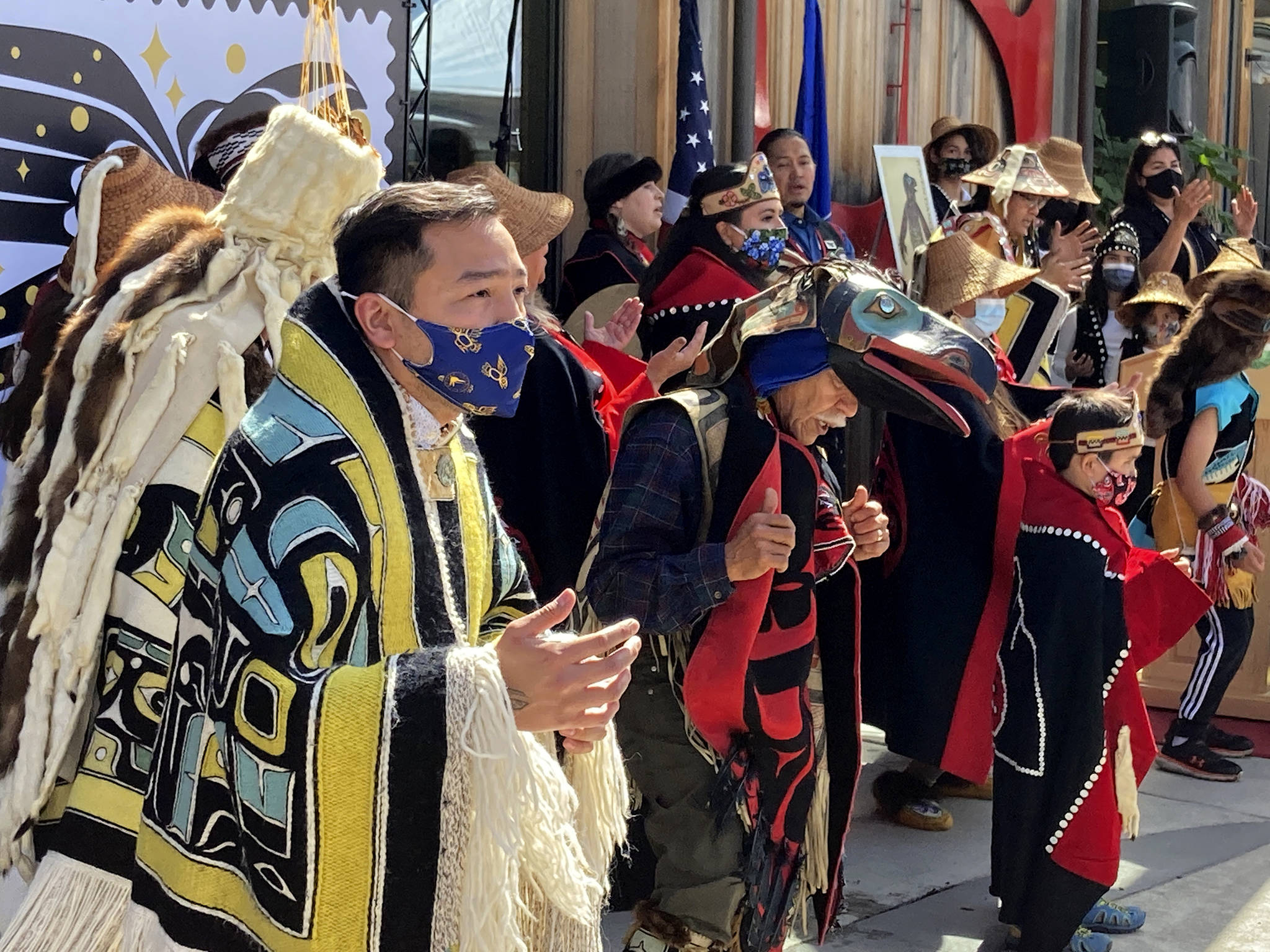 Rico Worl, foreground left, dances during a ceremony on Friday, July 30, 2021, in Juneau, Alaska, that marked the release of a stamp he created for the U.S. Postal Service. Worl, an Alaska Native artist, has said he hopes the Raven Story stamp will be a gateway for people to learn about his Tlingit culture. (AP Photo/Becky Bohrer)