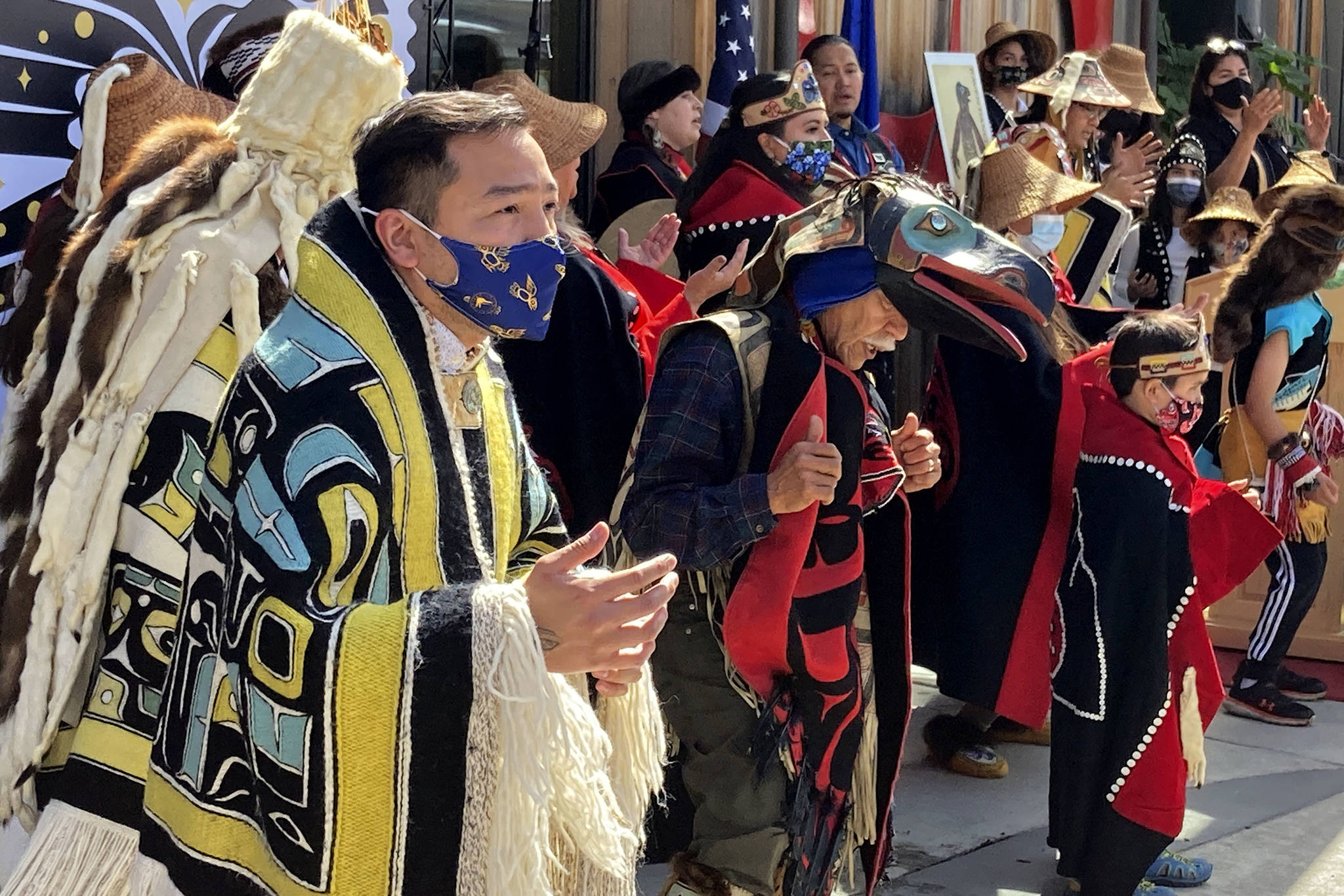 Rico Worl, foreground left, dances during a ceremony on Friday, July 30, 2021, in Juneau, Alaska, that marked the release of a stamp he created for the U.S. Postal Service. Worl, an Alaska Native artist, has said he hopes the Raven Story stamp will be a gateway for people to learn about his Tlingit culture. (AP Photo/Becky Bohrer)