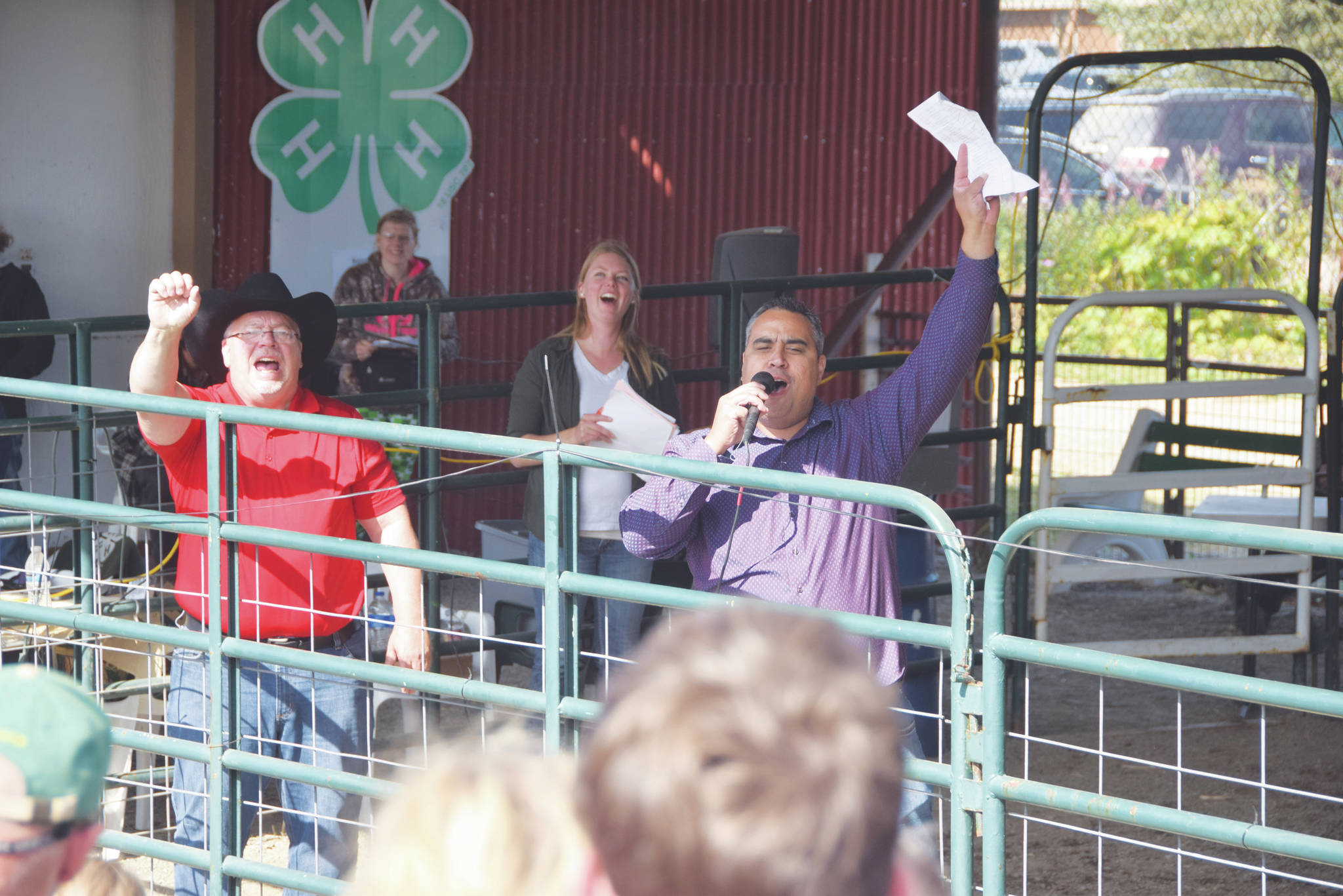 Auctioneers Andy Kriner, left, and Rayne, Reynolds celebrate a successful sale during the 4H Junior Market Livestock Auction at the Kenai Peninsula Fair on Aug. 17, 2019 at the fairgrounds in Ninilchik, Alaska. (Photo by Brian Mazurek/Peninsula Clarion)
