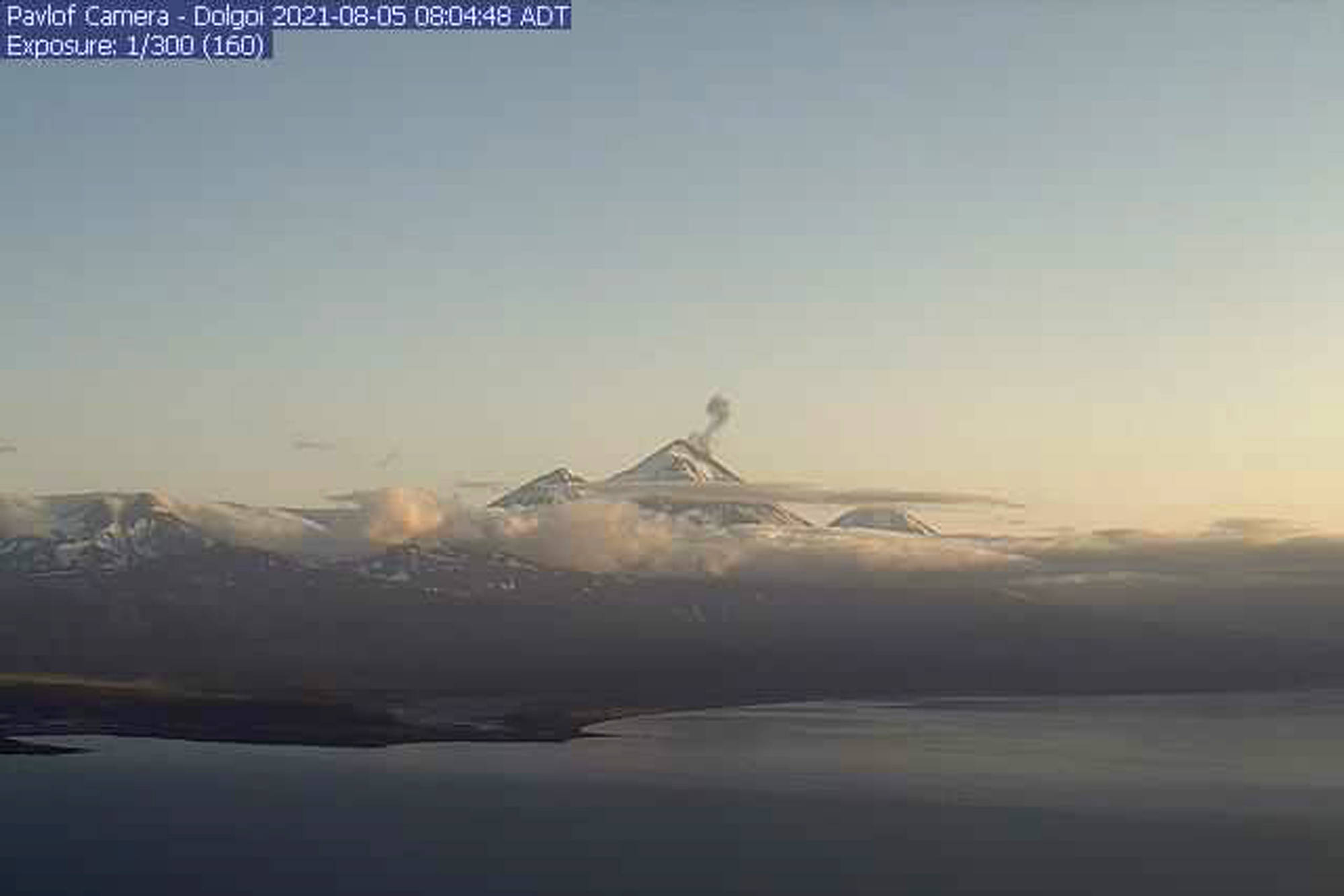 In this webcam image provided by the Alaska Volcano Observatory, is the Pavlof Volcano in a state of eruption with episodic low-level ash emissions on Thursday, Aug. 5, 2021. Three remote Alaska volcanos are each in a state of eruption, one producing lava and the other two blowing steam and ash. So far, no small communities near any of the three have been impacted, Chris Waythomas, a geologist with the Alaska Volcano Observatory, said Thursday. (Alaska Volcano Observatory via AP)