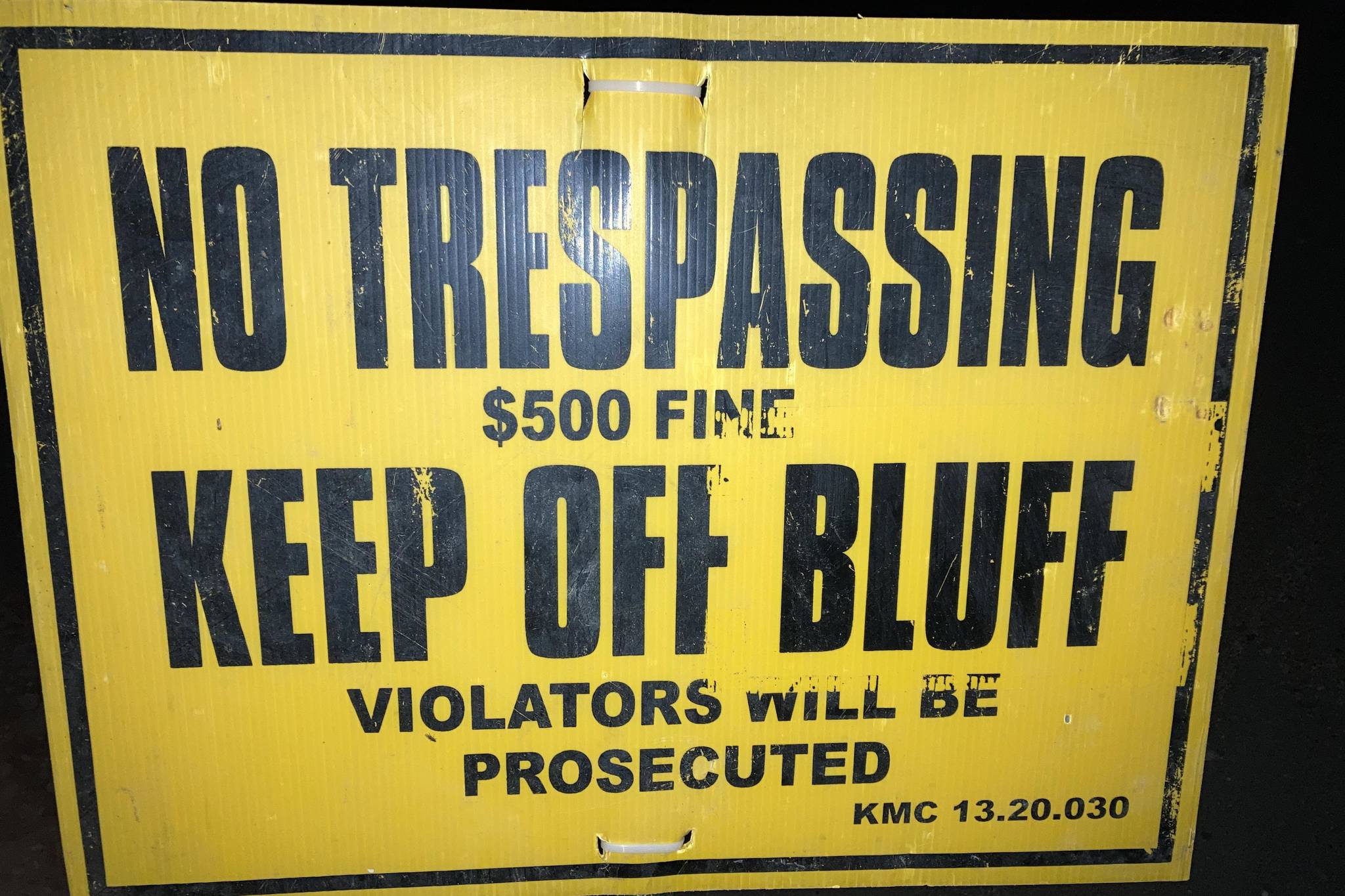 A sign at North Kenai Beach warns pedestrians away from the eroding bluffs. (Photo by Jeff Helminiak/Peninsula Clarion)