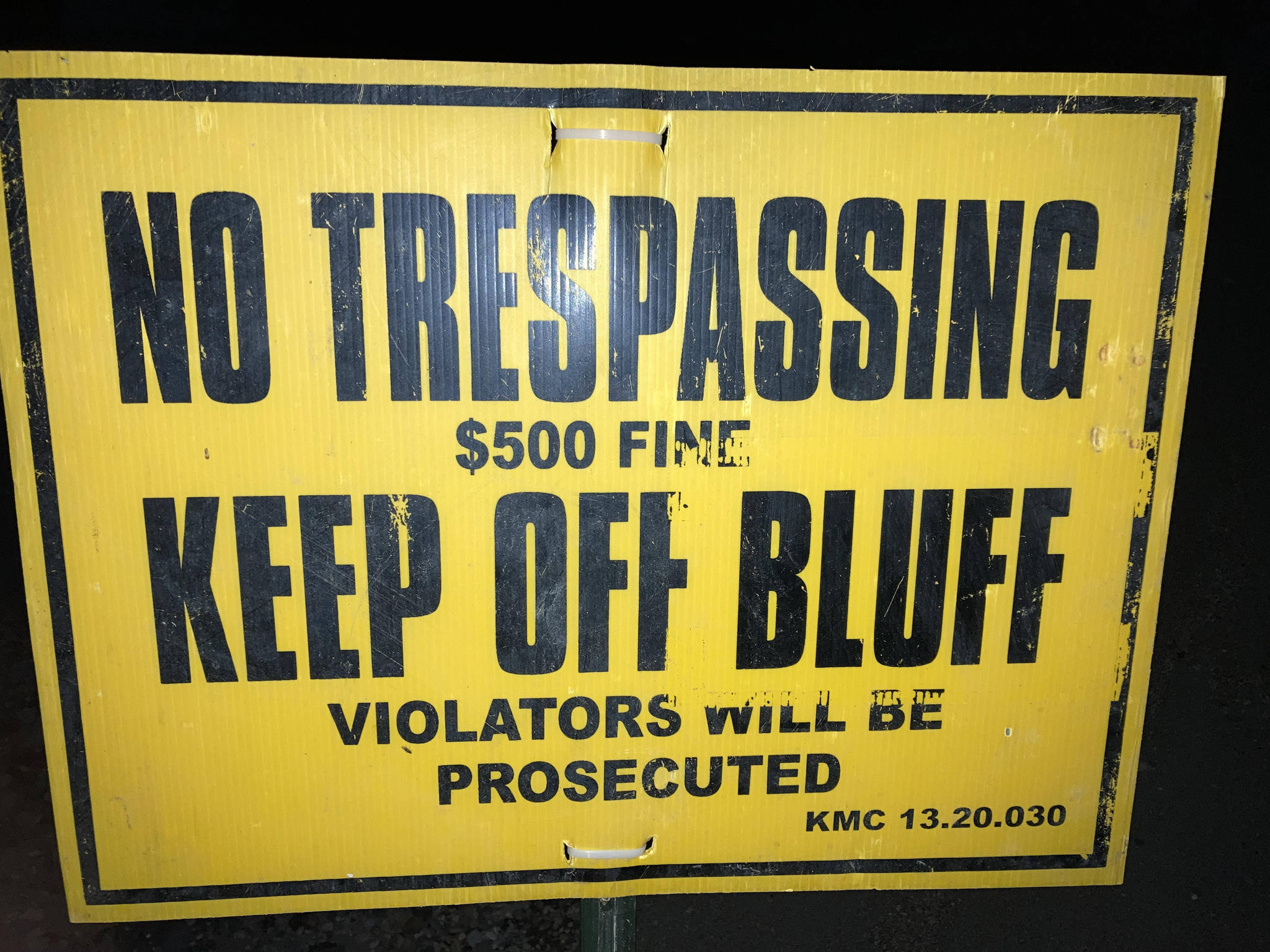 A sign at North Kenai Beach warns pedestrians away from the eroding bluffs. (Photo by Jeff Helminiak/Peninsula Clarion)