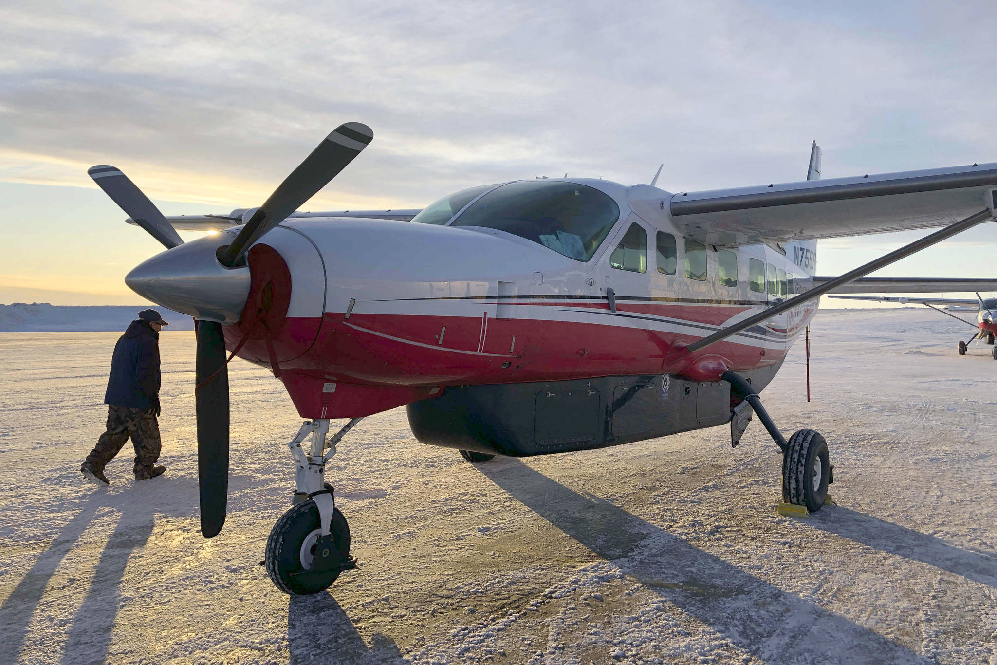 This Jan. 18, 2020, photo shows people preparing to get on a Ravn Connect airplane at the airport in Bethel, Alaska, for a flight to Toksook Bay. (AP Photo/Mark Thiessen, File)