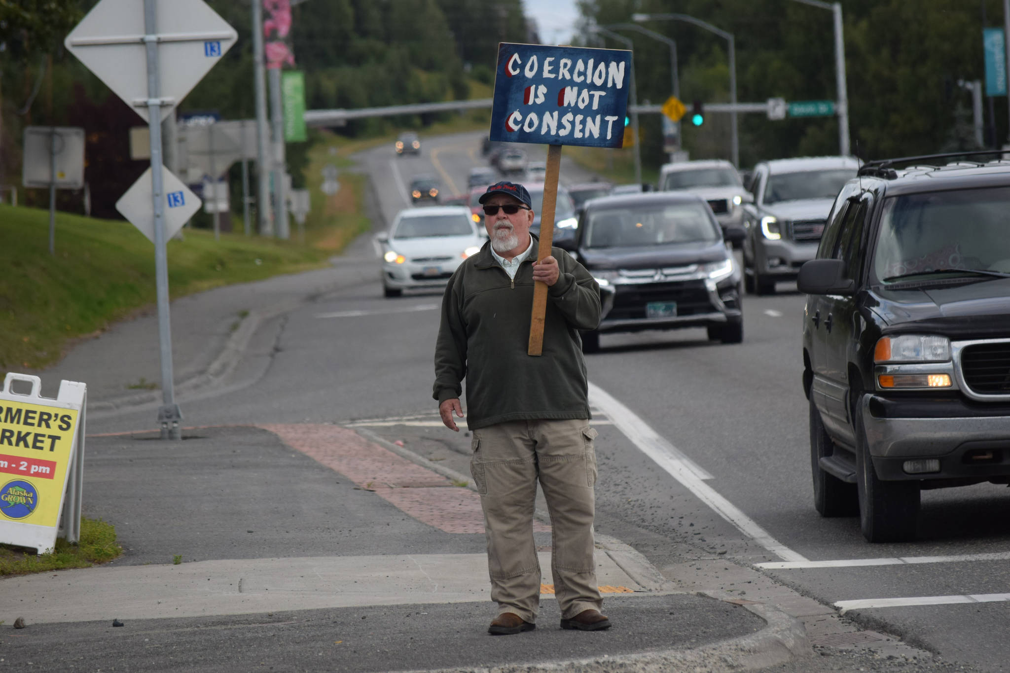 Kevin Hall stands at the “Y” intersection of the Kenai Spur and Sterling highways in Soldotna on Saturday, Aug. 14 to protest mandatory COVID-19 vaccines and mitigation protocols. (Camille Botello/Peninsula Clarion)