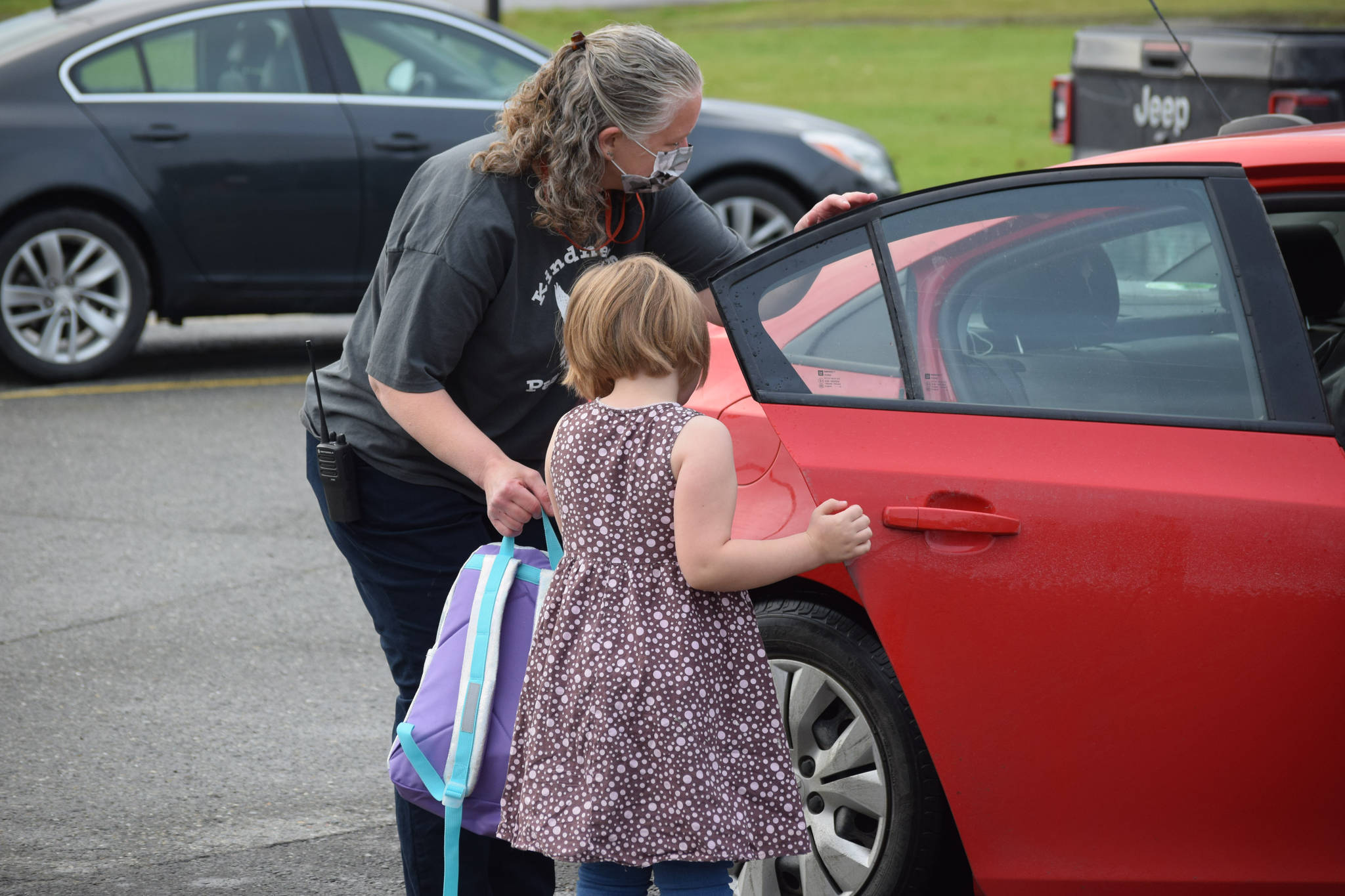 Sterling Elementary School Principal Denise Kelly helps Melody Gage, second grade, with her backpack on Tuesday, Aug. 17, 2021. (Camille Botello/Peninsula Clarion)
