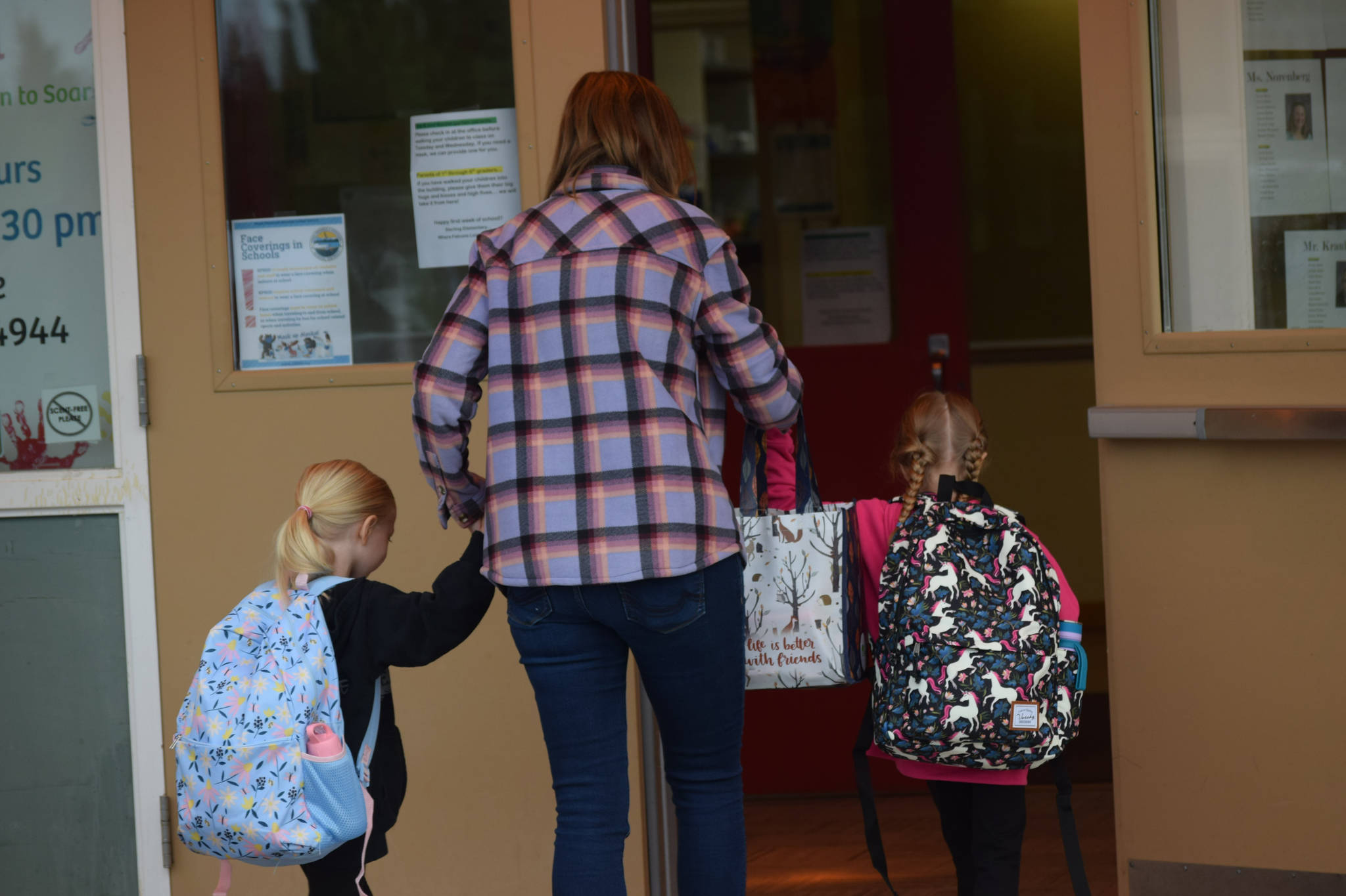 Katina Jacobson walks her daughters Evalyn, kindergarten, and Zoey, second grade, into Sterling Elementary on their first day of school on Tuesday, Aug. 17, 2021. (Camille Botello/Peninsula Clarion)