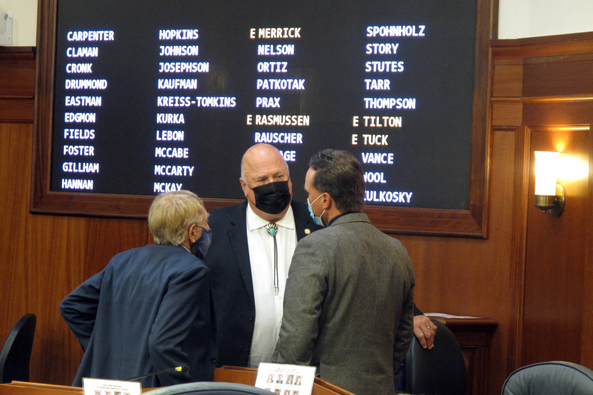 Alaska state Rep. Kevin McCabe, center, speaks to Reps. Laddie Shaw, left, and Ben Carpenter, right, during a break in the House floor session on Friday, Aug. 20, 2021, in Juneau, Alaska. Lawmakers are meeting in special session, with the annual dividend paid to residents a key topic. (AP Photo/Becky Bohrer)